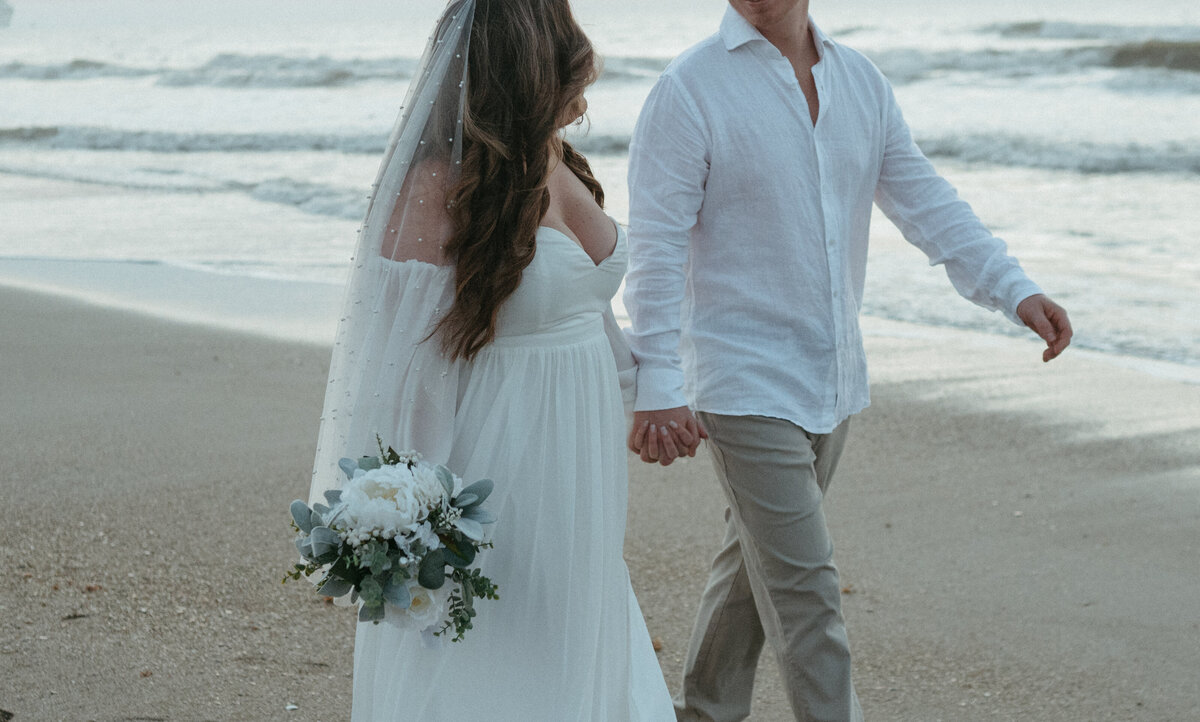 couple walking on beach during destination wedding