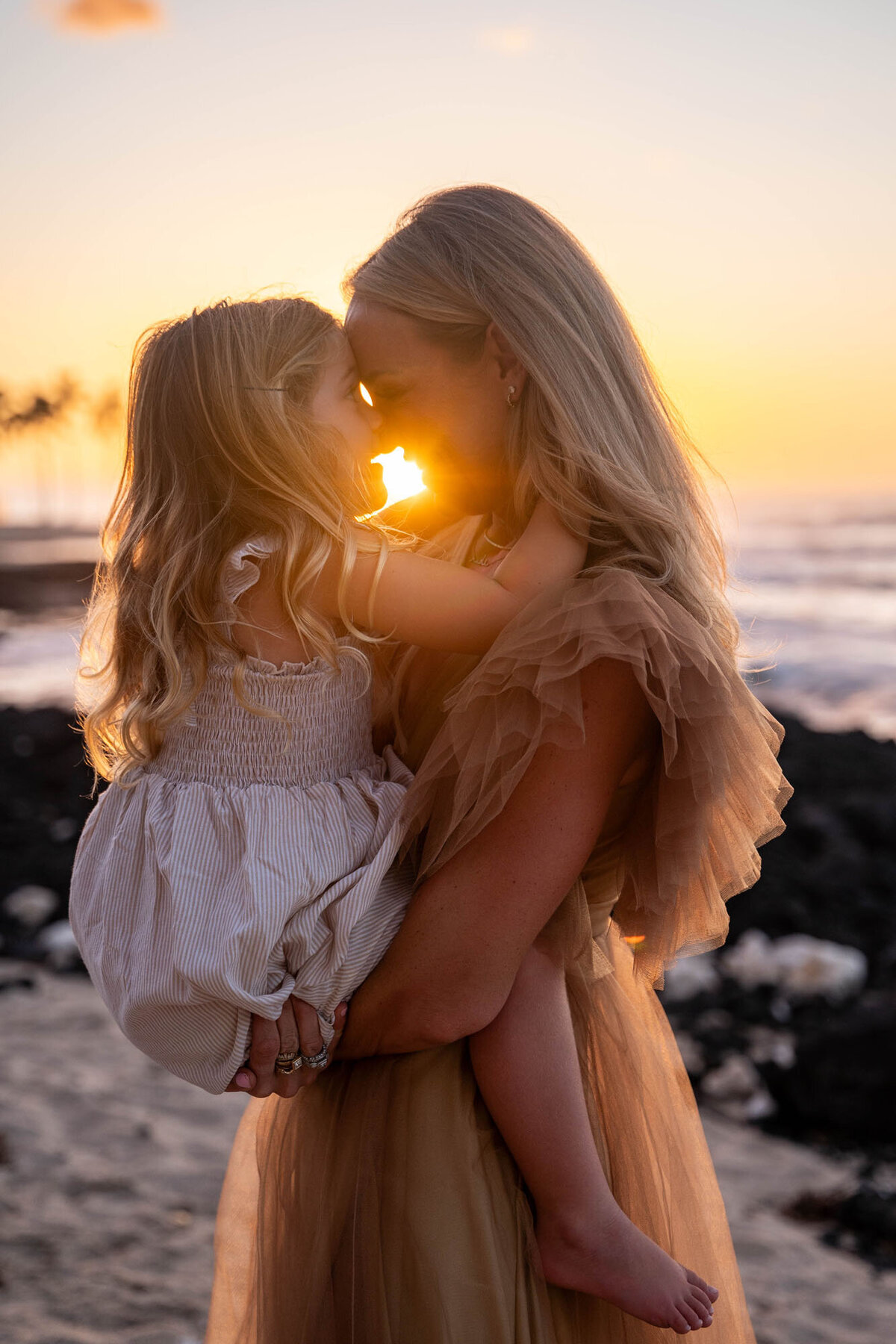 Sunset family portrait with mom and daughter, taken by big island family photographer