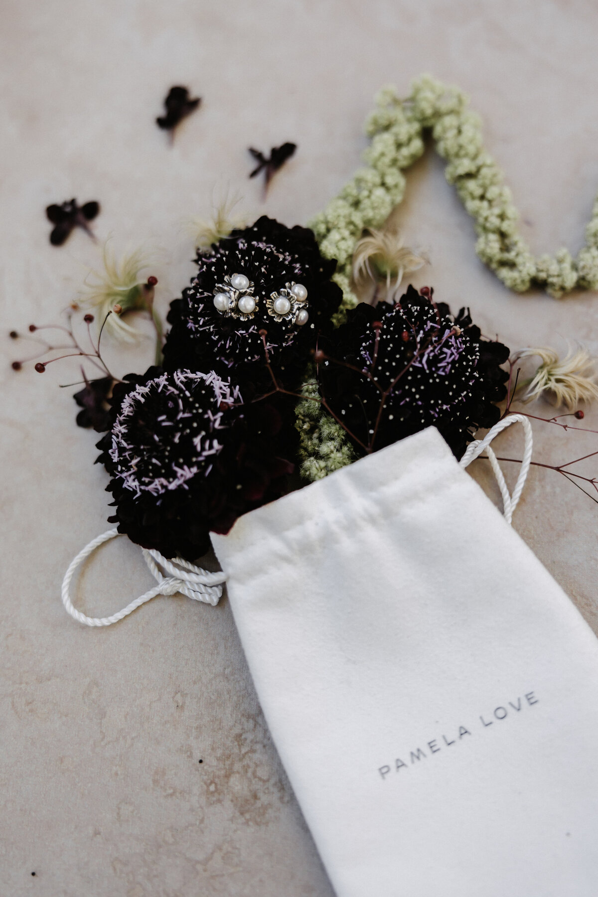 Wedding Photography,  styled flatlay photo of pamela love jewelry with florals