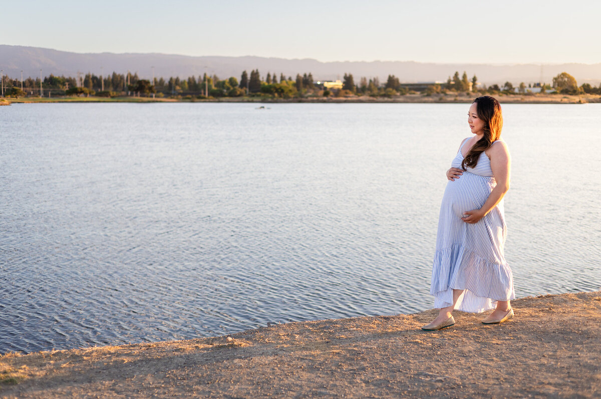 Pregnant woman in blue striped dress walking by the water at golden hour — Bay Area Maternity Portfolio - Ellobelle Photography Family Photographer