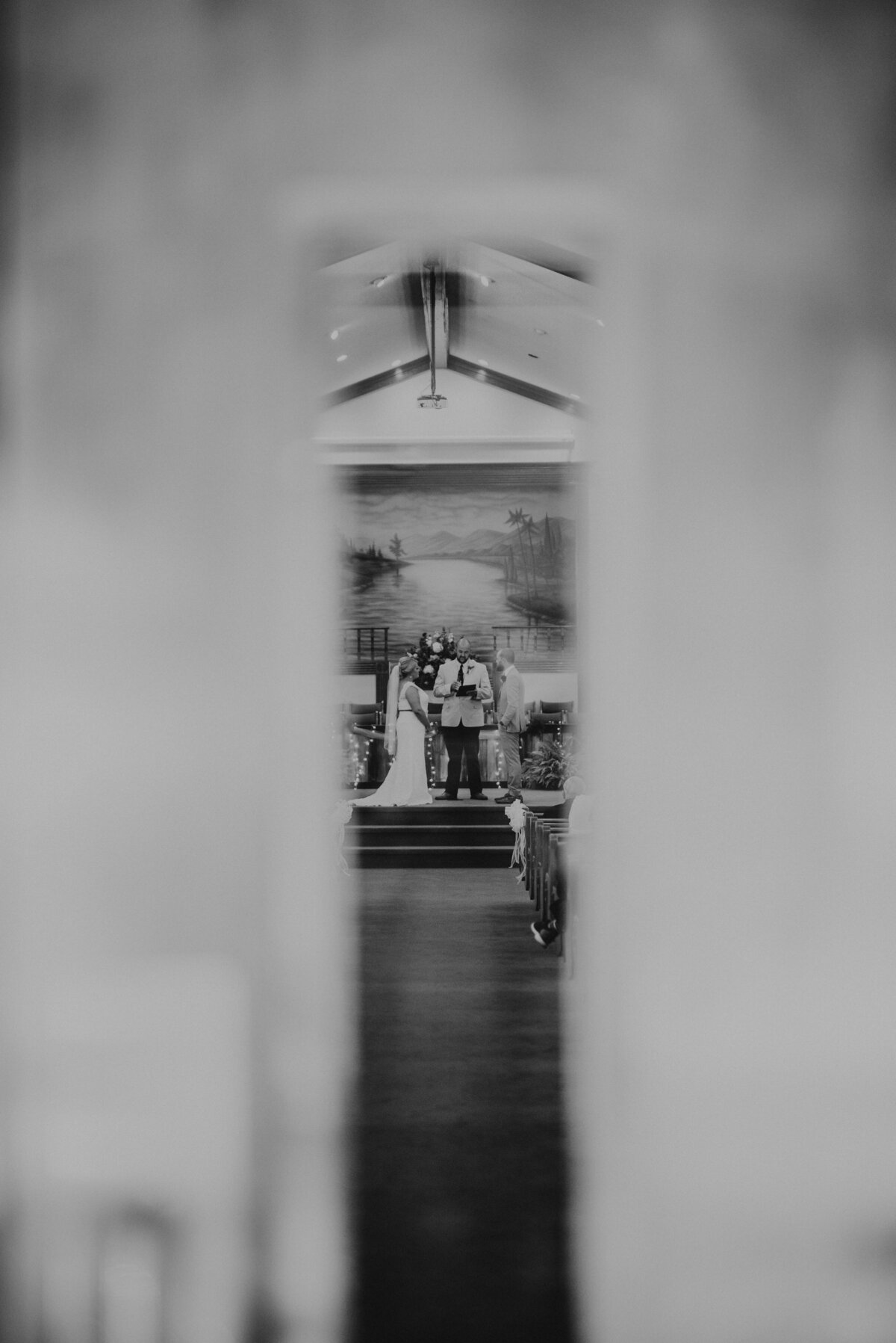 A bride and groom through the crack of a doorway
