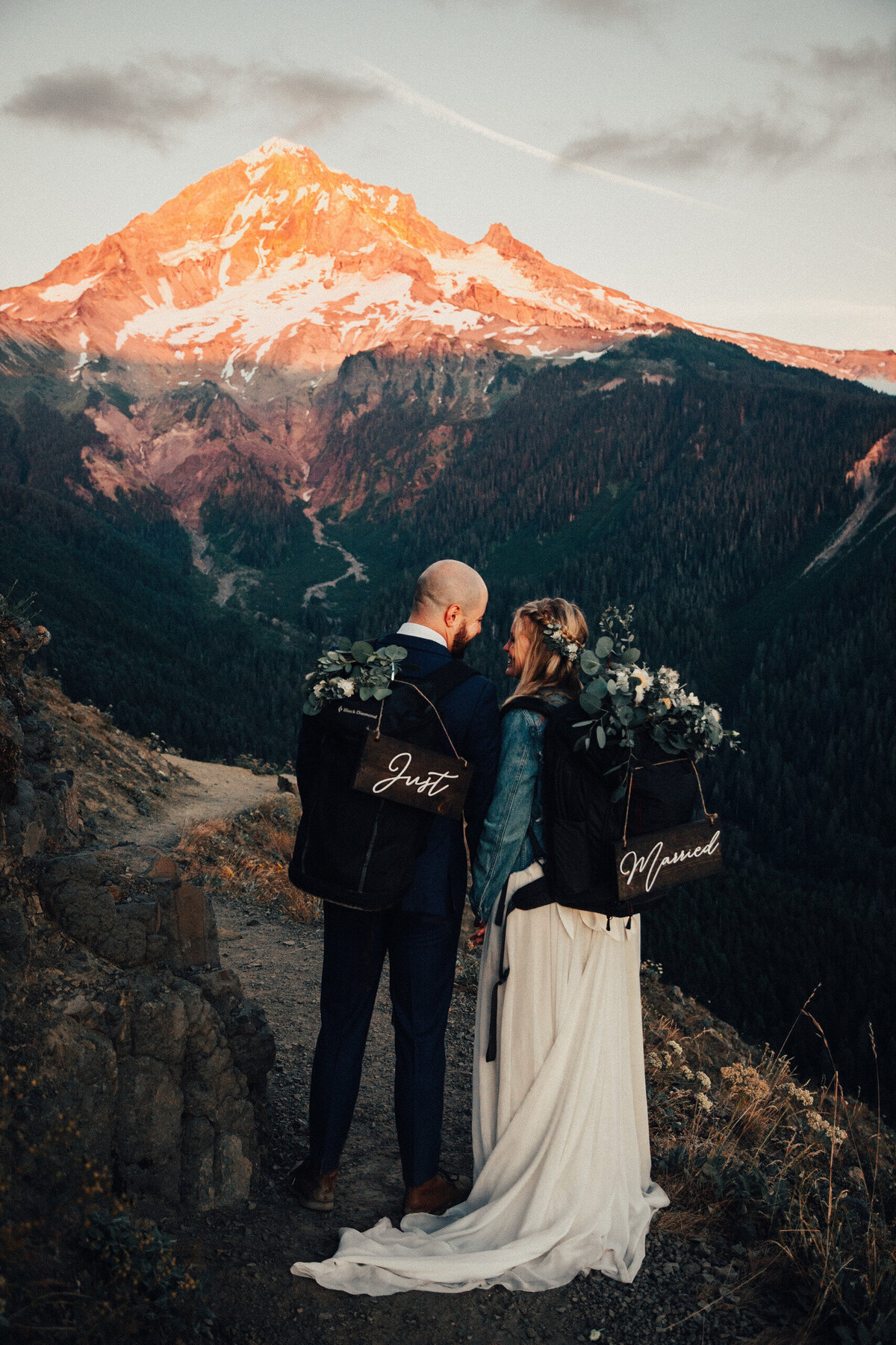 Couple poses in front of Mount Hood with backpacks on