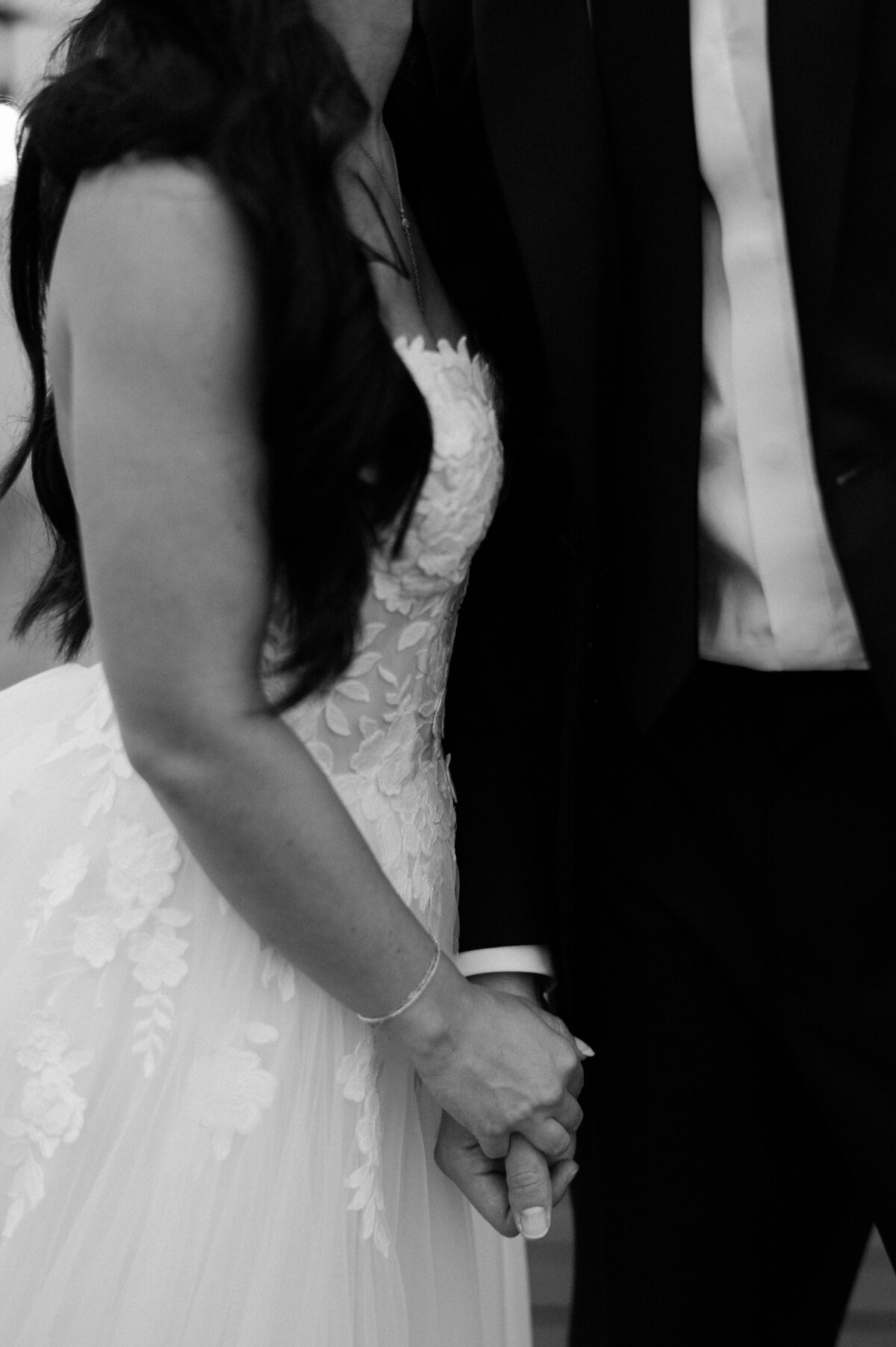 Bride and groom below the waist holding hands