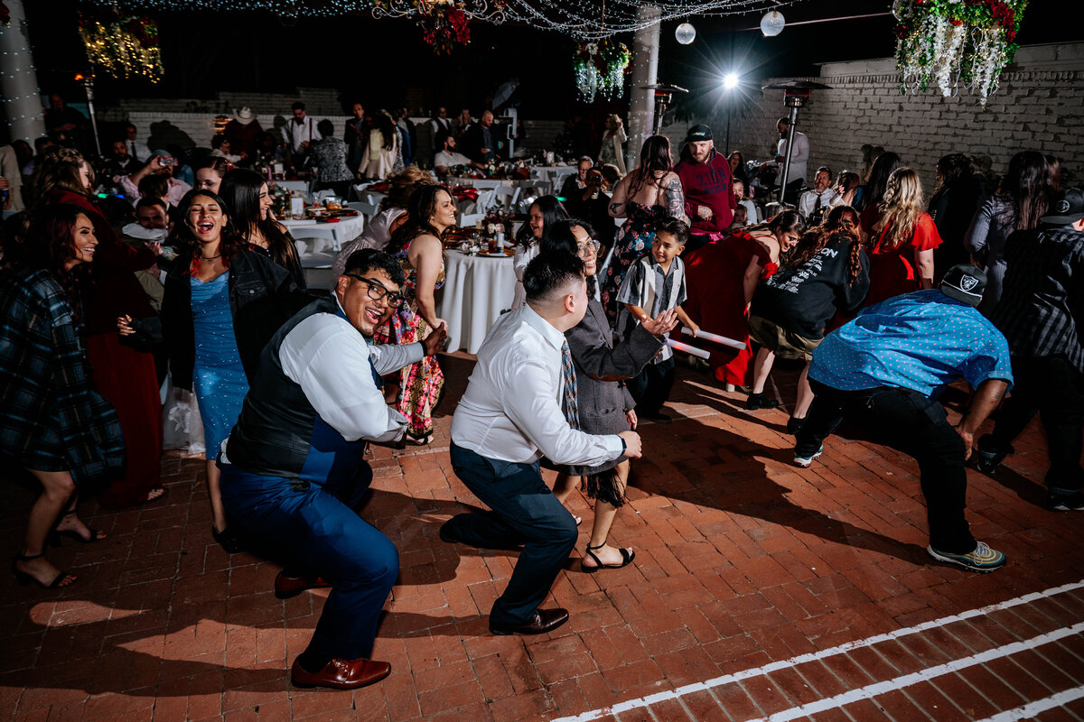 Guests dancing to the Cha Cha Slide with everyone mid-squat on the “get down low” part of the song
