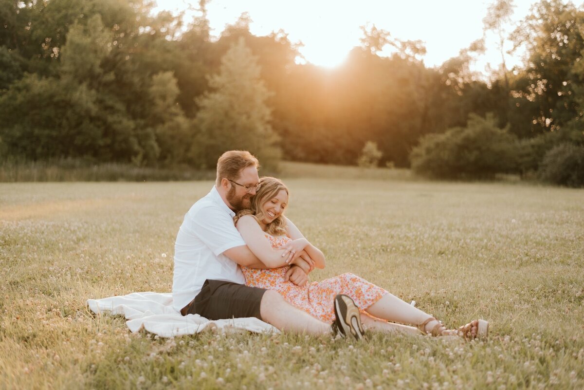 couple embrace in field portfolio image for amber lynn photography