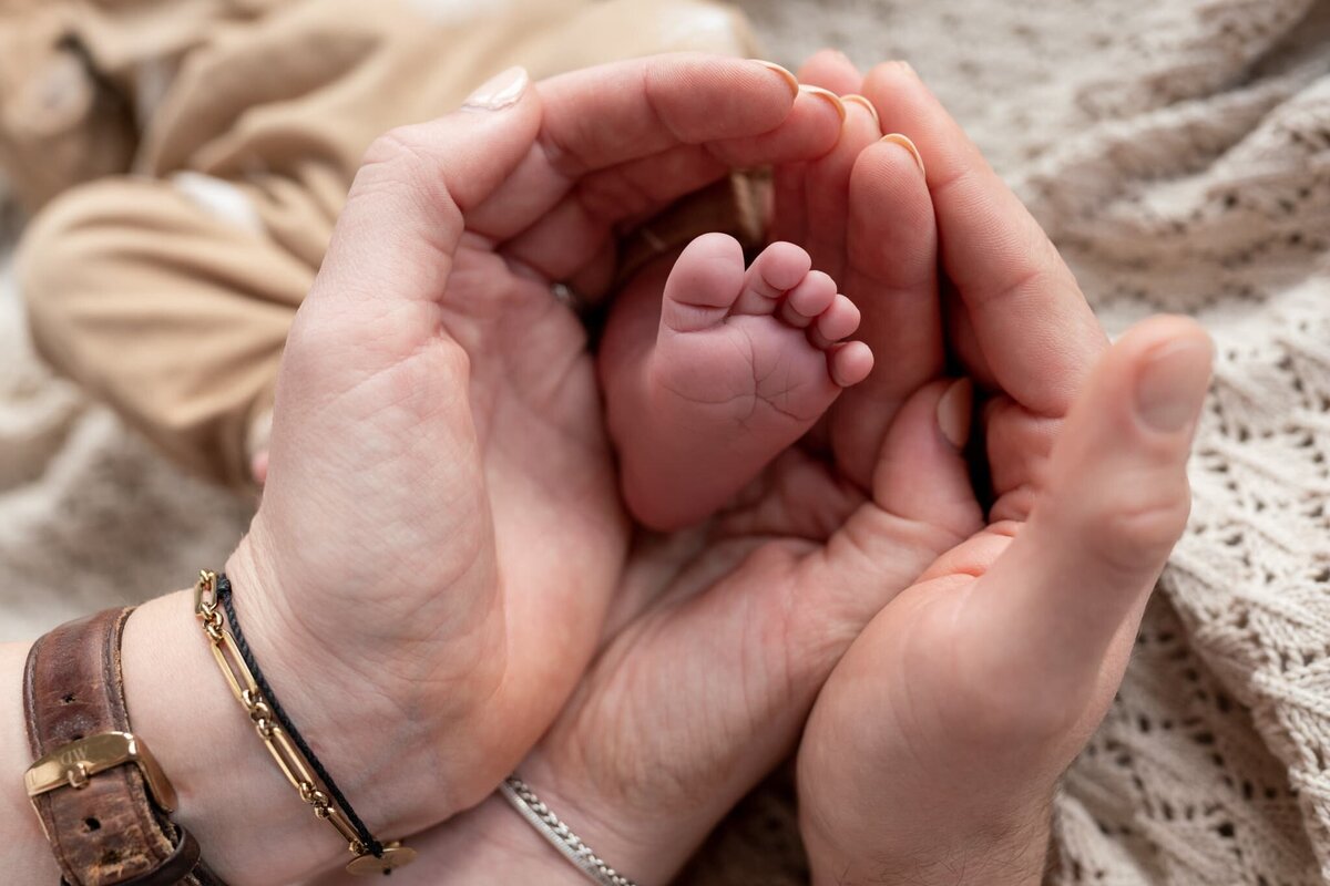 Newborn fotoshoot Groningen Drenthe en Friesland - baby voetje in handen van ouders.