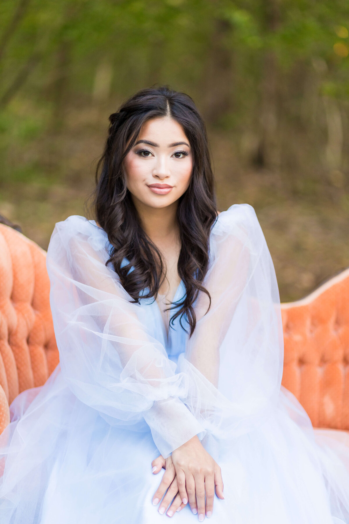 Bride sitting on orange sofa with hands outstretched in front of her at Nashville wedding
