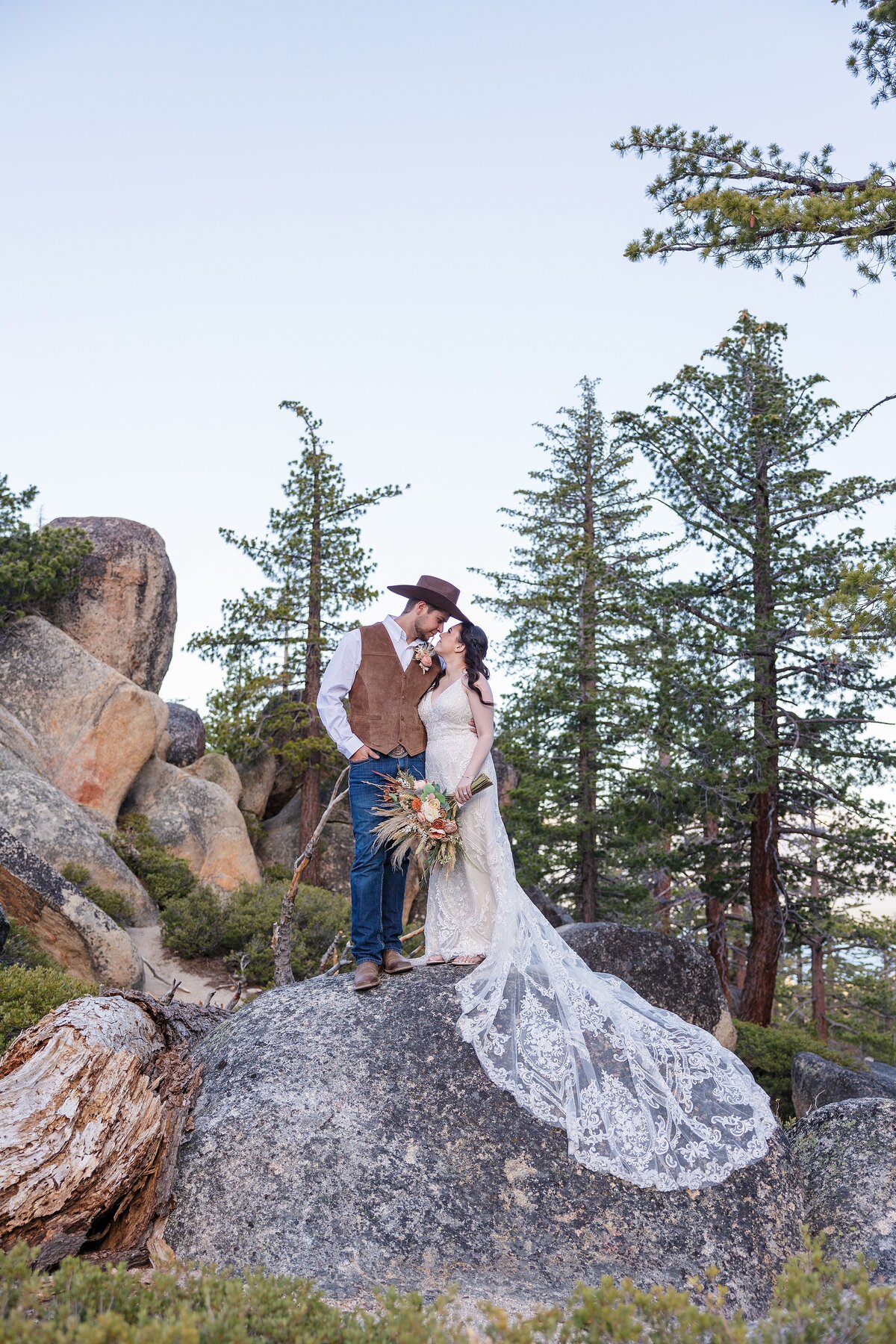 newlyweds standing on boulders in Lake Tahoe