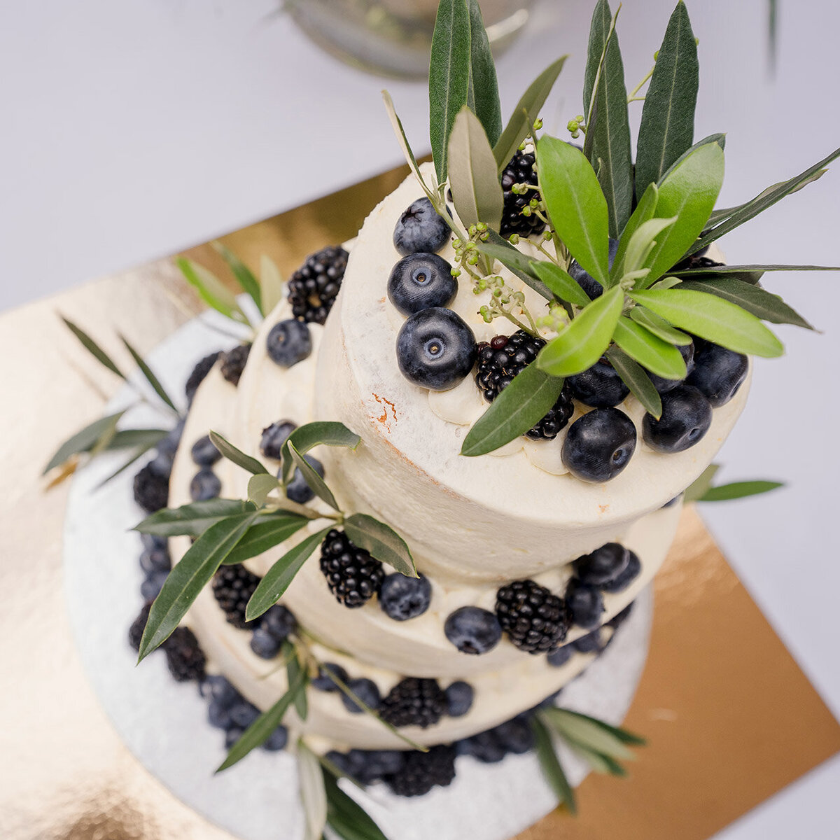 Bruidstaart van Berg's Bakery met verse bessen en olijfbladeren