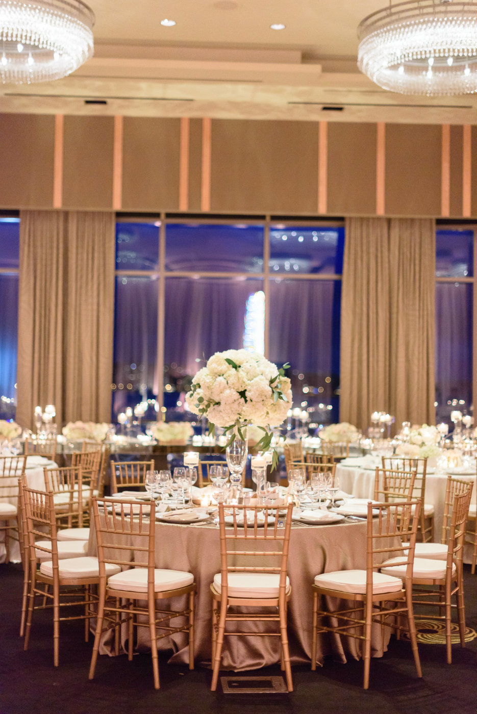 Tall white centerpiece with gold chiavari chairs are a classic look for a winter ballroom wedding.