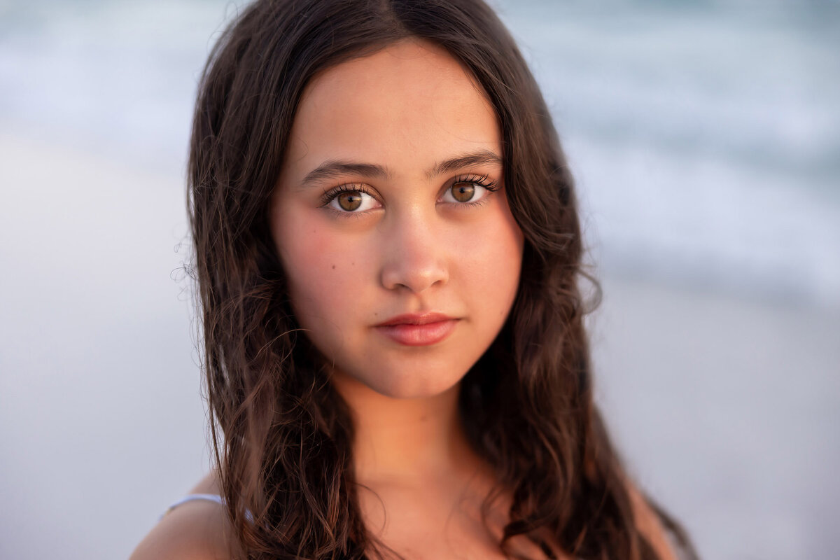 close-up of a dark haired and brown eyed teen on the beaches of Watercolor, FLorida. 