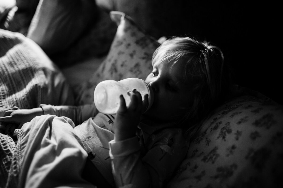 Little girl drinking milk before bed during at home family photoshoot