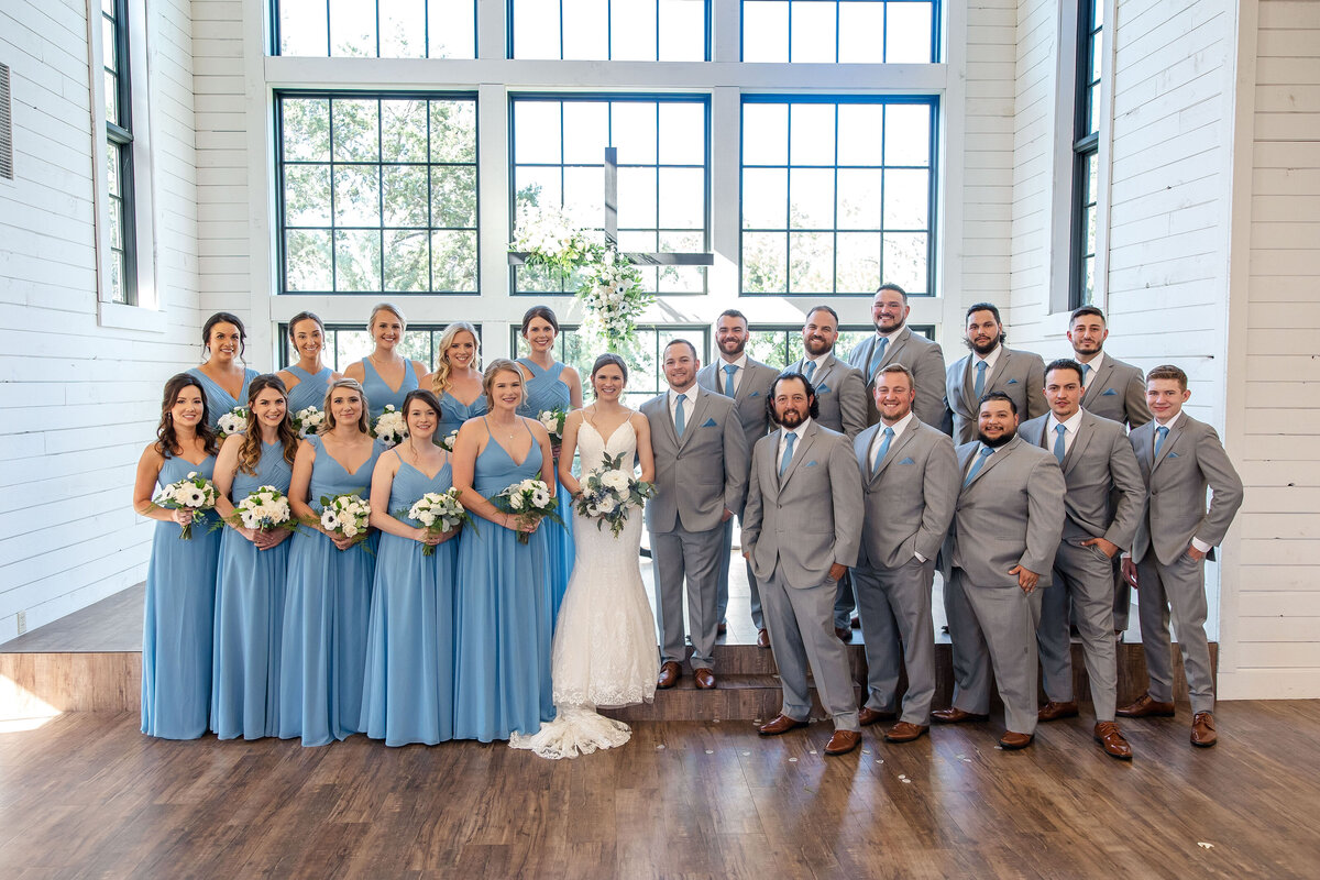 wedding party at Morgan Creek Barn in Dripping Springs Texas in blue dresses and gray suits