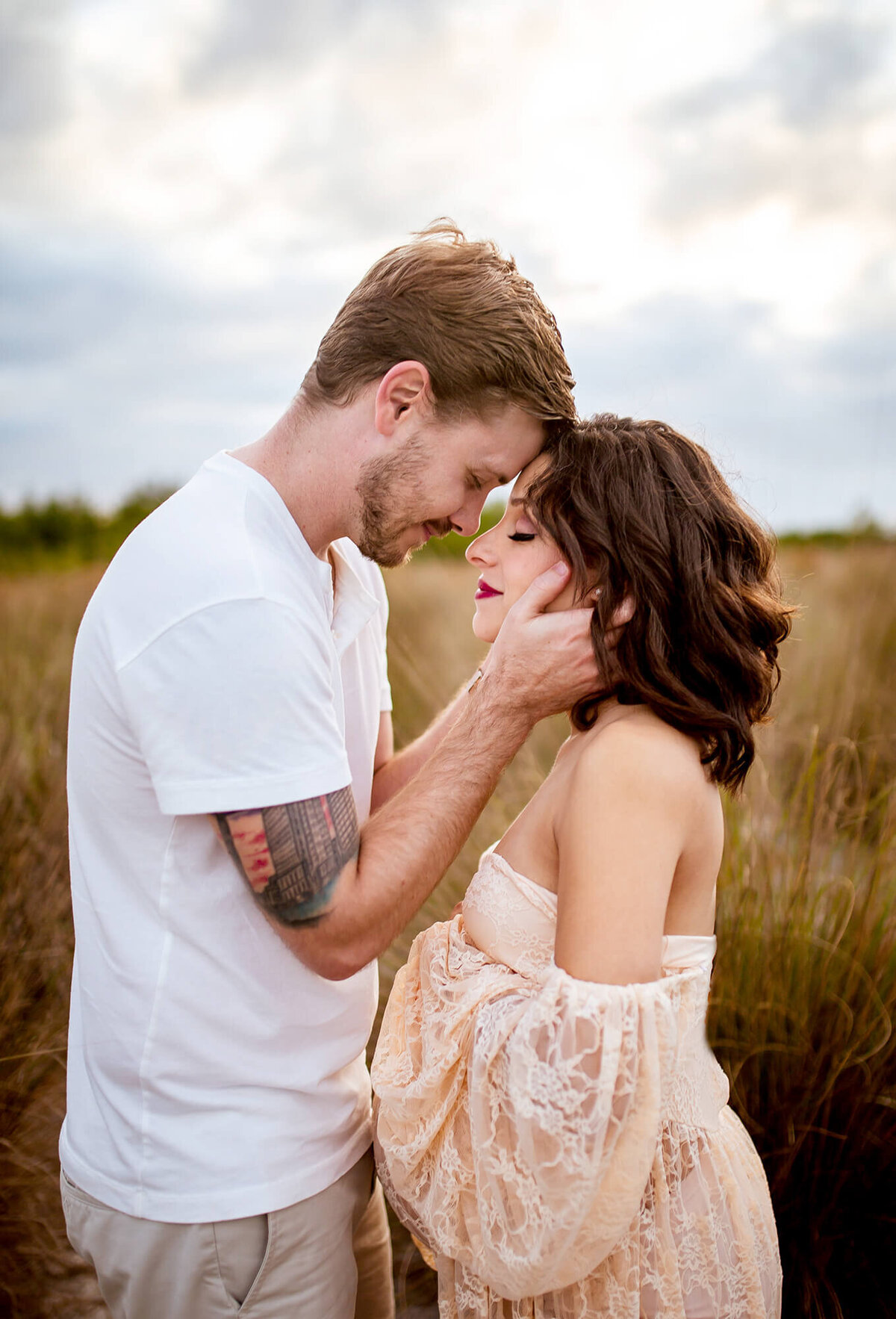 Stunning golden light maternity session. Intimate moment with husband about to kiss wife and smiling. Captured at Cypress Point Park in Tampa, FL