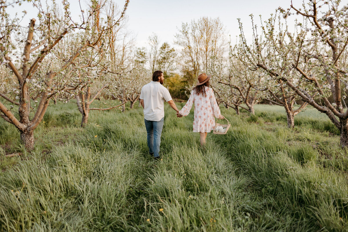 couple holding hands in field