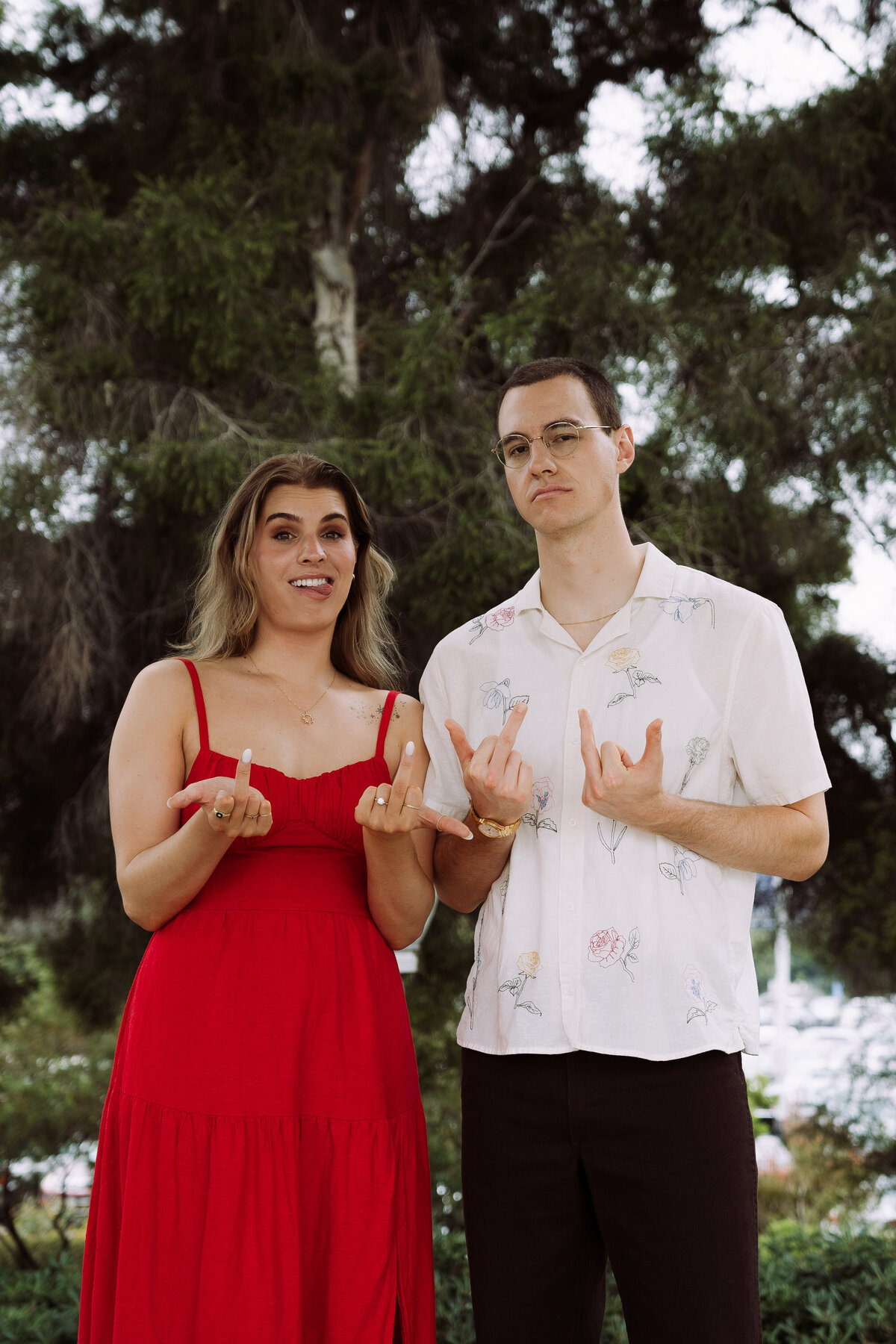 sarcastic couple flipping off camera