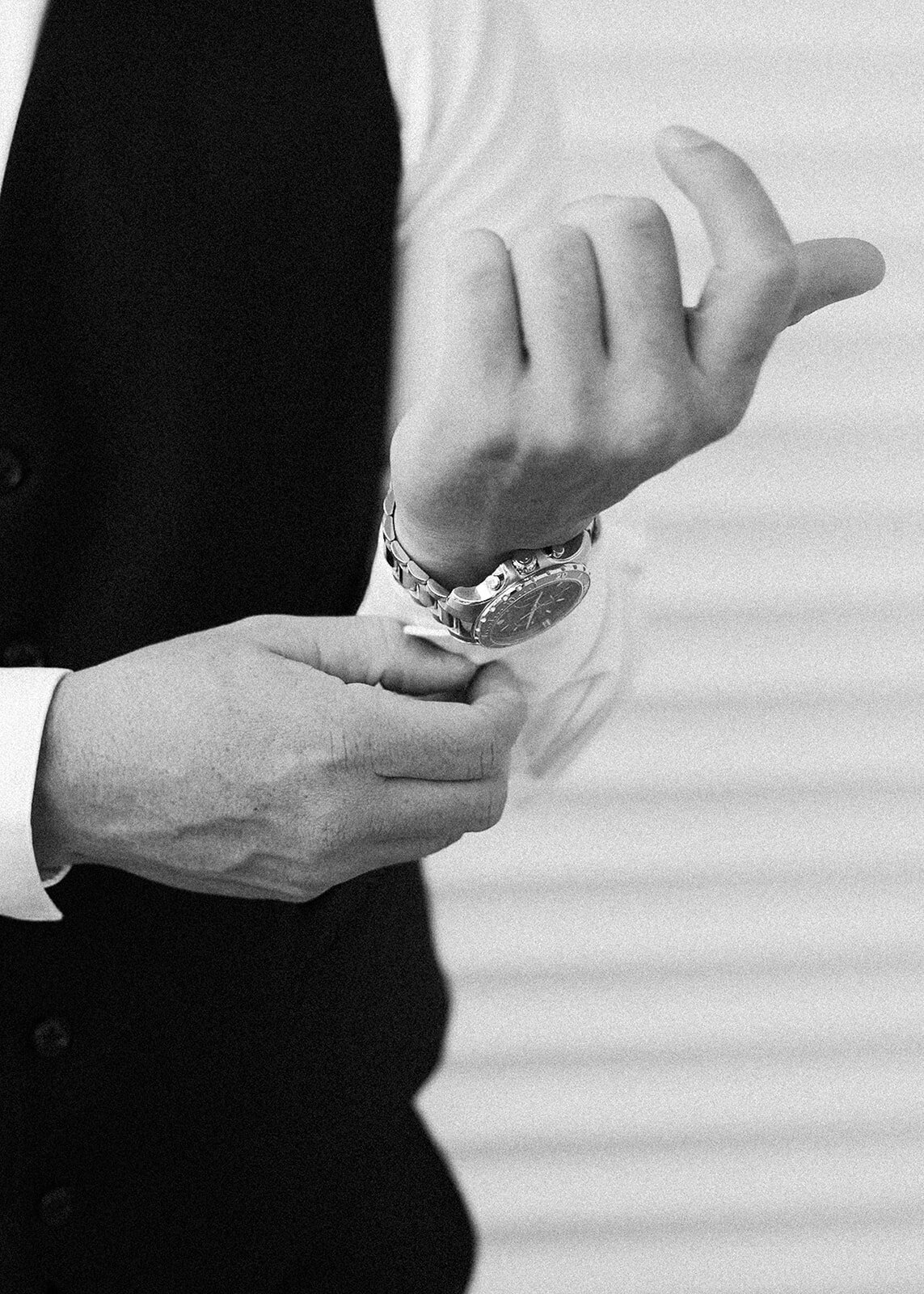 A timeless black-and-white close-up of the groom adjusting his cufflinks, showcasing his elegant wristwatch and tailored wedding attire. Captured during Stephanie and Bradley’s wedding in Islamorada by Claudia Amalia Photography.