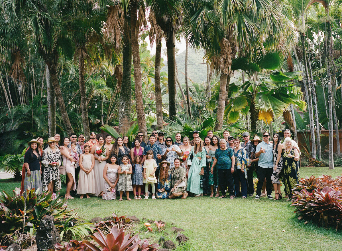 Joyful wedding party in Hawaii gathered on the beach, captured on film by Kate Winters in a candid, documentary style