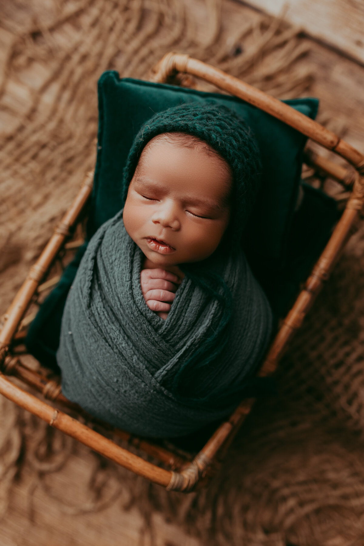 newborn baby boy wrapped in emerald green