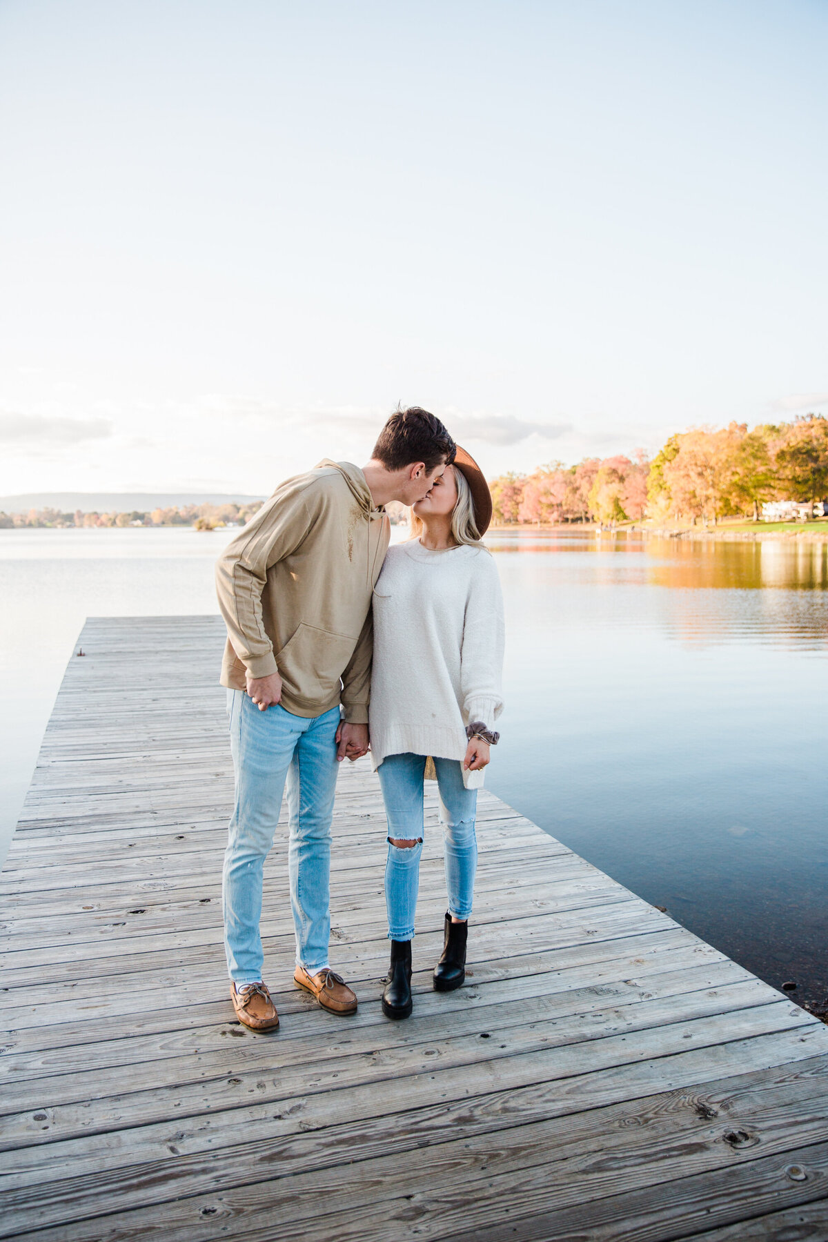 couple kissing on a lake during fall