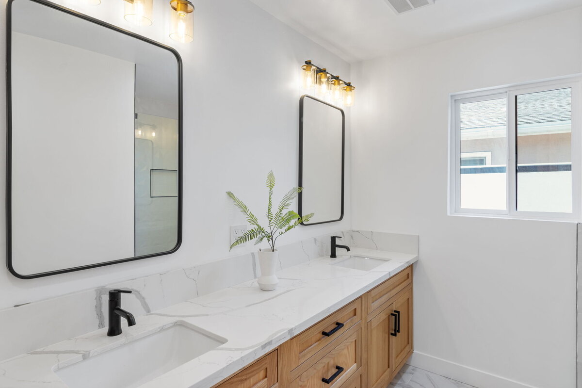 double-vanity-bathroom-natural-wood-cabinets-marble-countertops