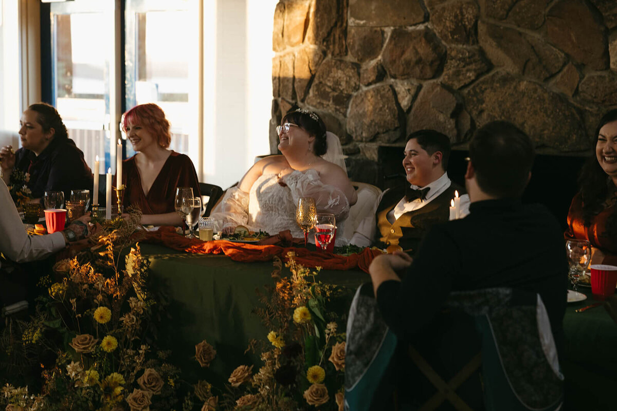A wedding couple smile at their indoor wedding reception.