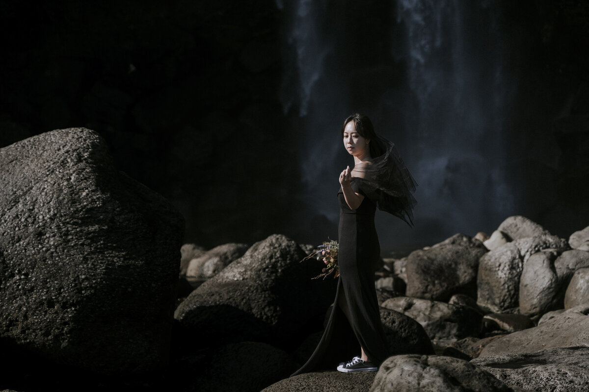 the bride standing on the rocks in front of Neajangsan waterfall