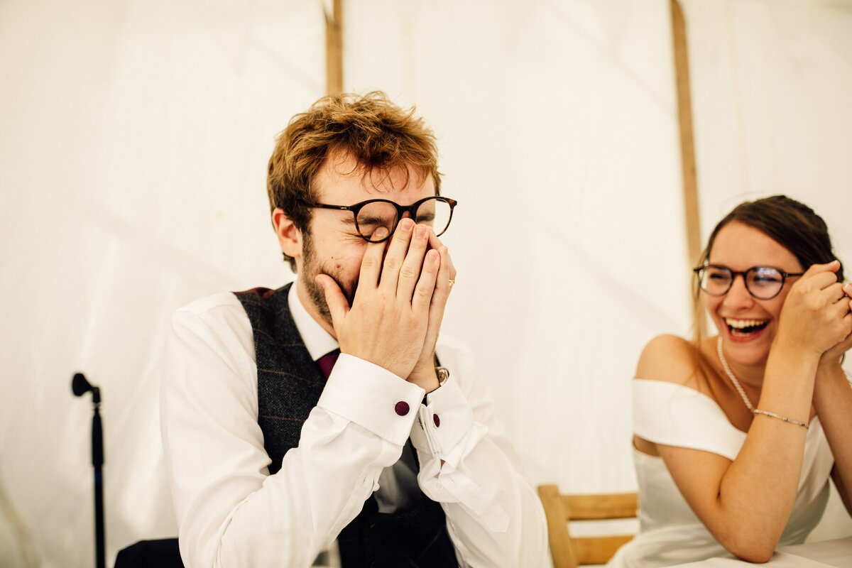 Bride and Groom laughing together at table