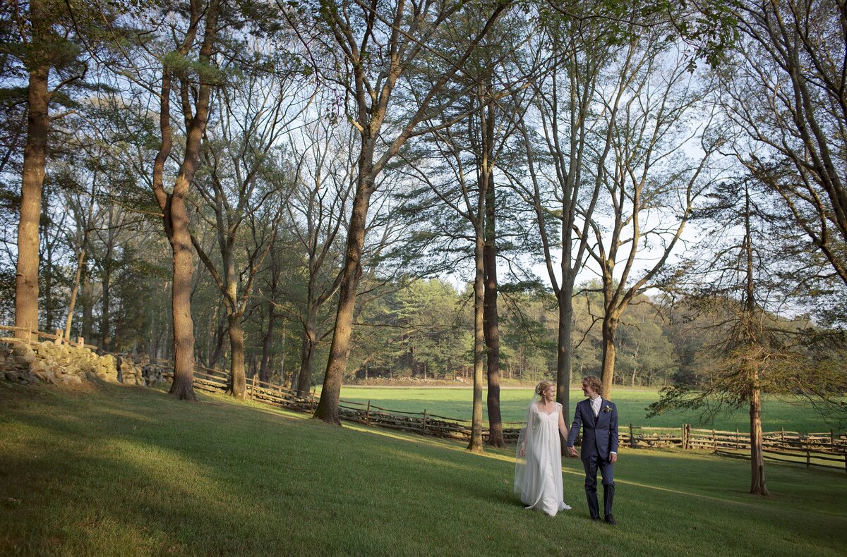 Bride and Groom walk through wooded private estate on their wedding day.