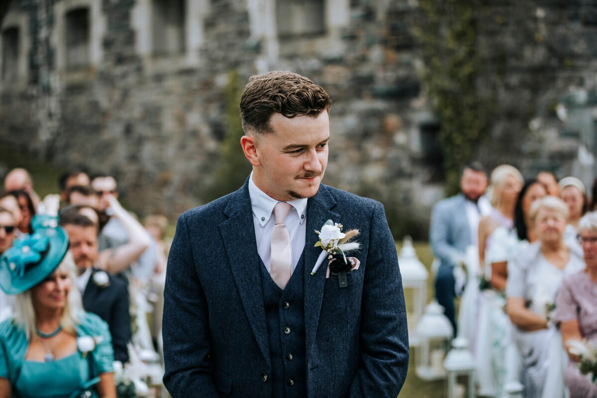The groom standing at the front of the aisle waiting for the bride