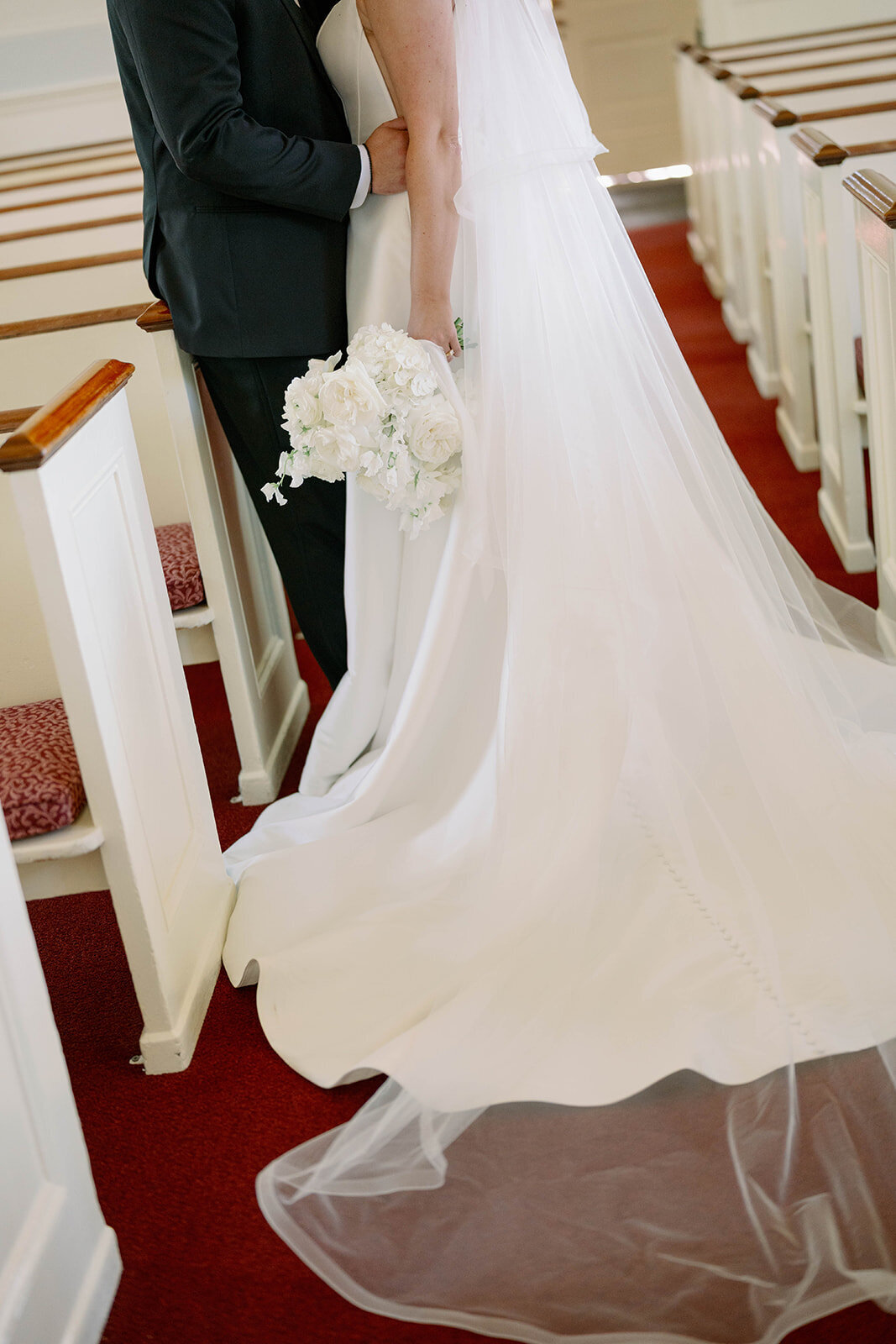 Bride and groom standing at the front of Martha-Mary Chapel, timeless chapel wedding portrait in Michigan.