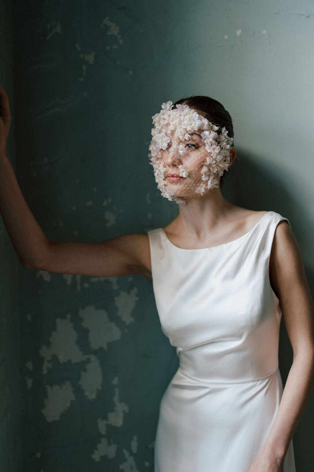 bride leaning against wall in wedding dress