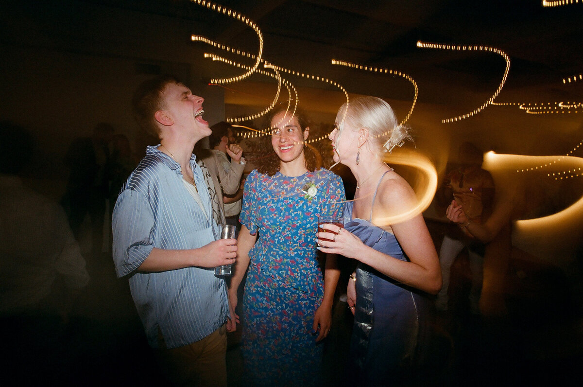 Guests at a wedding reception laughing.