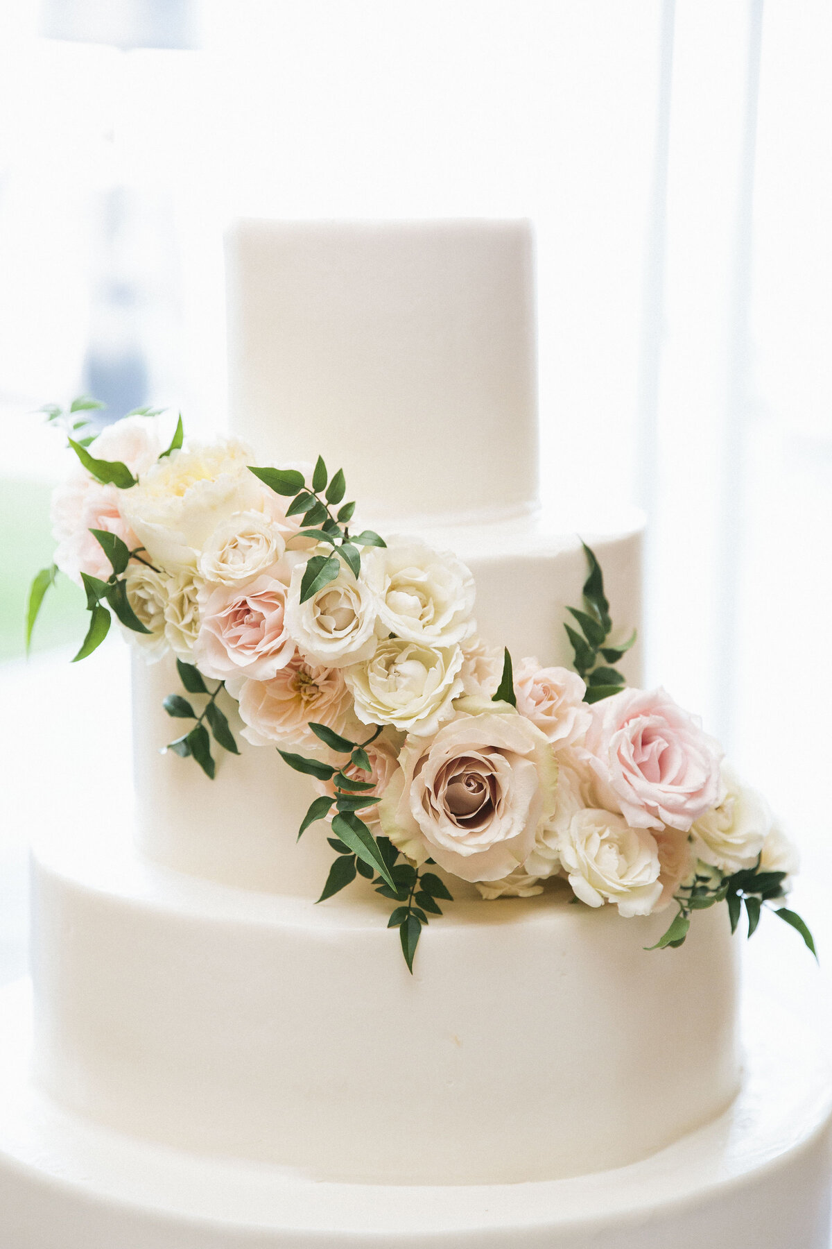 Wedding cake with florals on the tiers by Montilio's bakery
