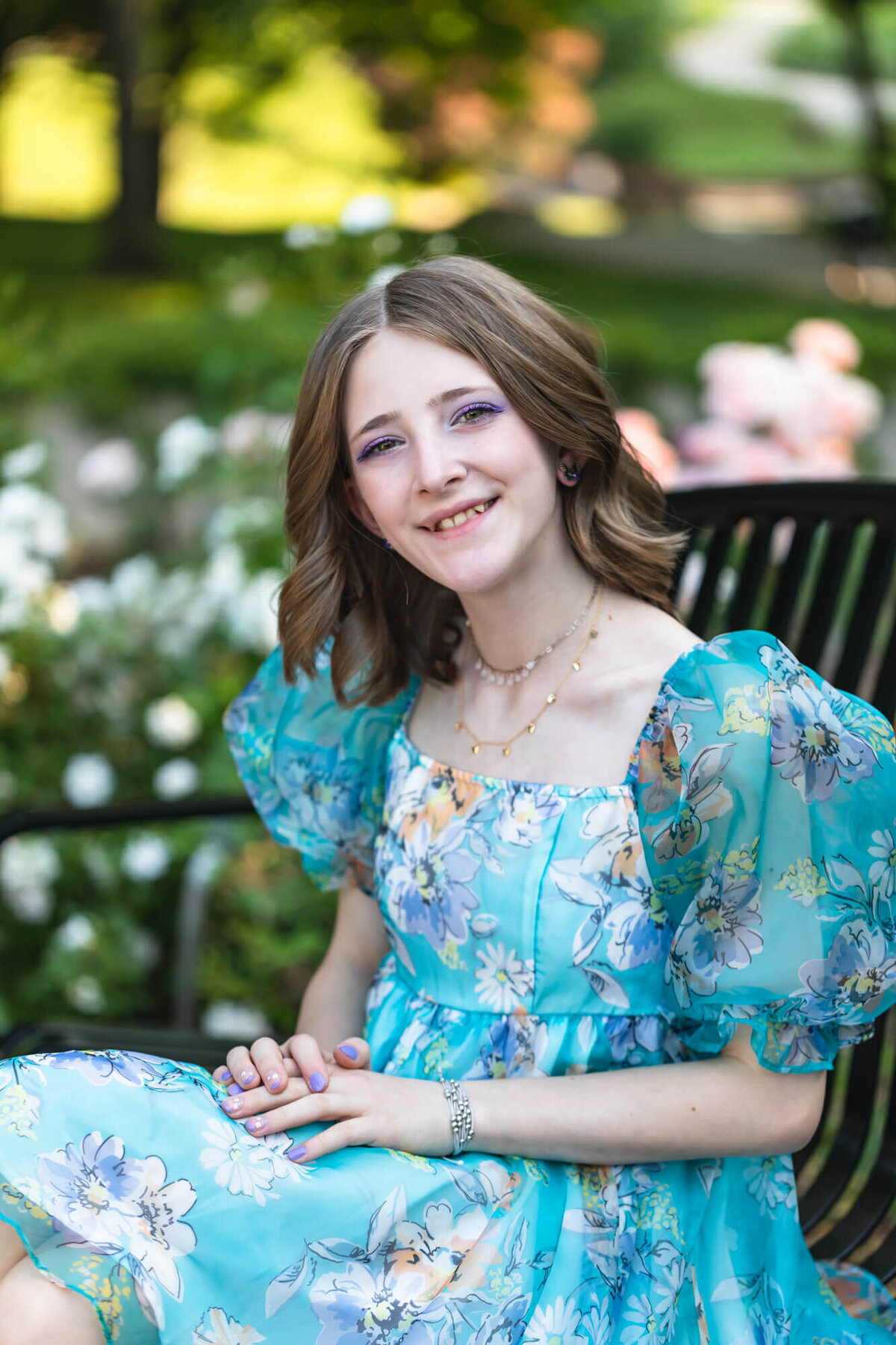 Pretty young teen girl with shoulder length dark blonde hair wearing a blue puffy sleeved floral dress. Captured by Springfield, MO teen photographer Dynae Levingston.