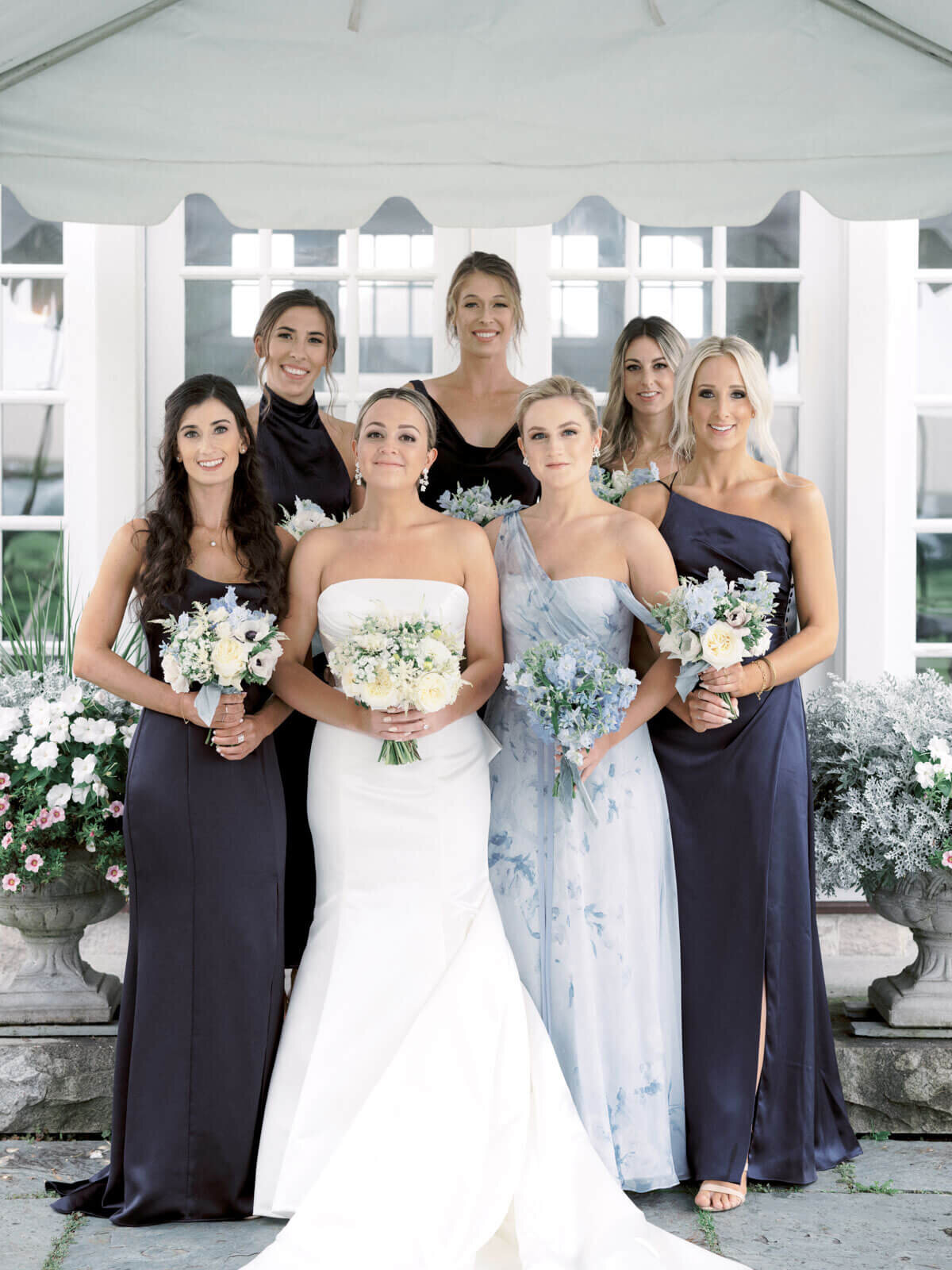 The beautiful bride and her pretty bridesmaids are holding flower bouquets at Lion Rock Farm, CT.  Image by Jenny Fu Studio