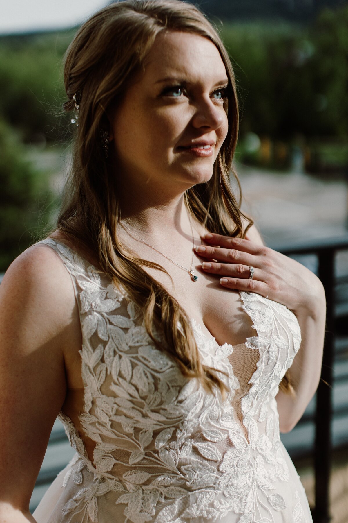 Bride poses on her wedding day in her lace leaved wedding dress.