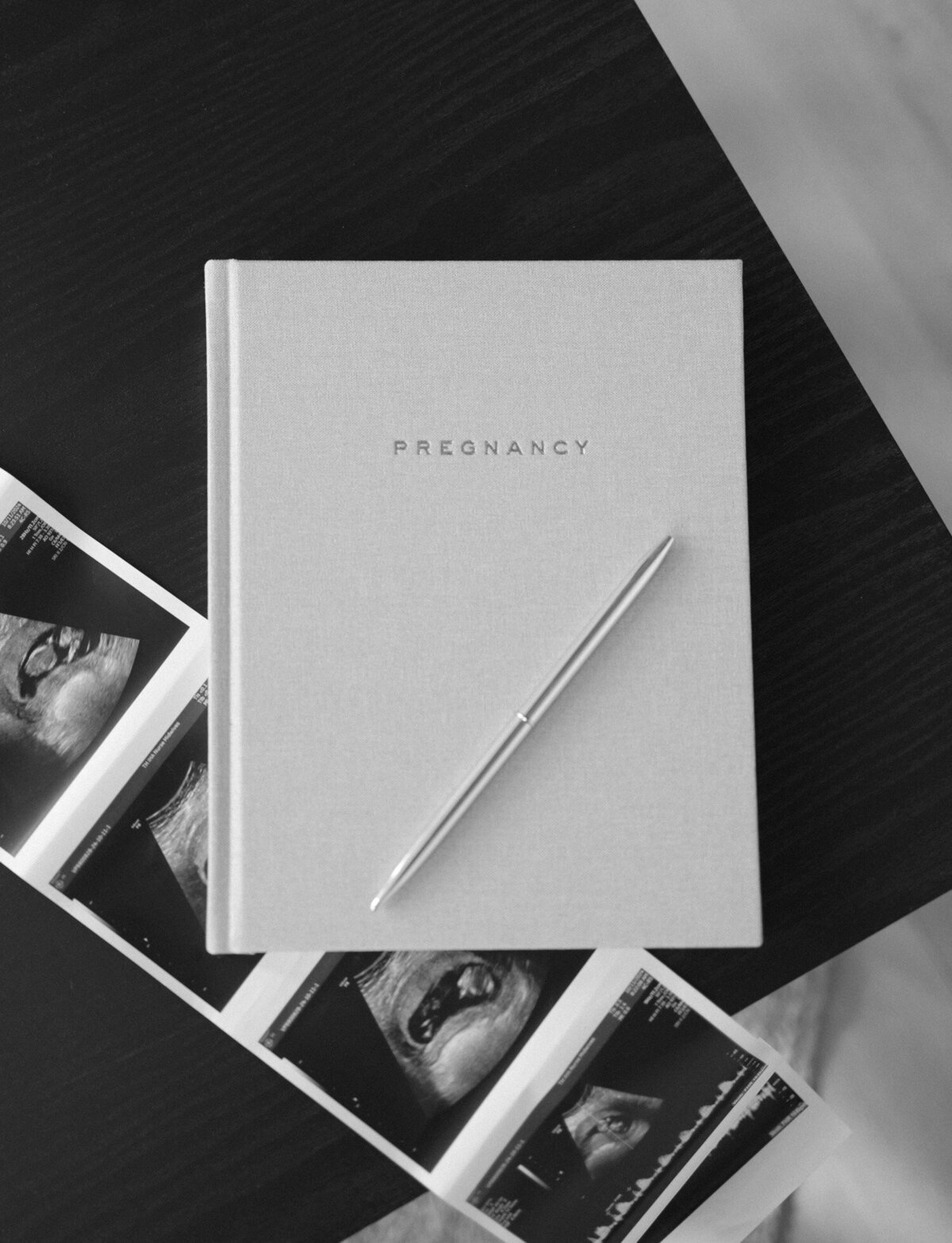 branding product photography of linen pregnancy journal, styled with ultrasound photo, pen
