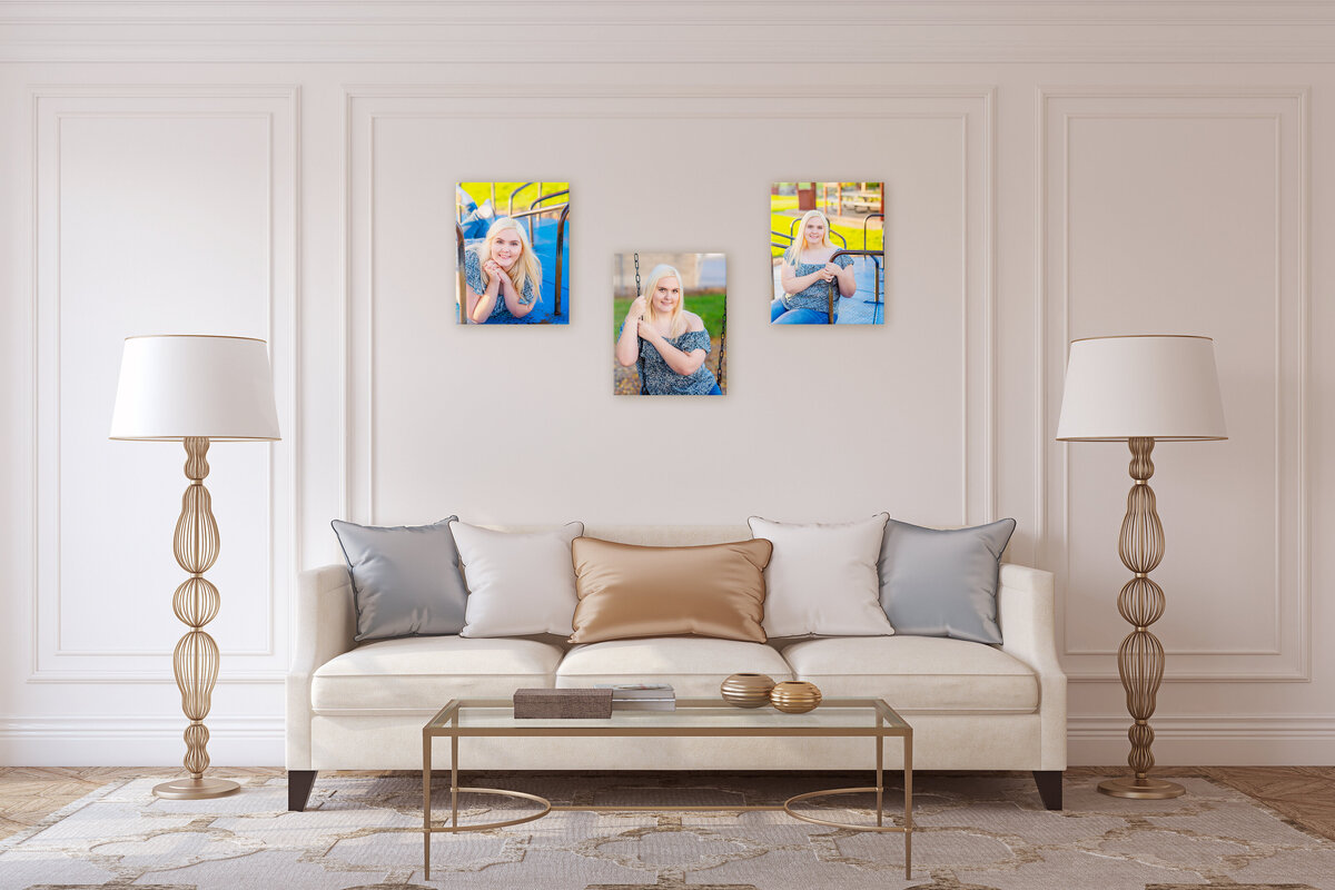 An elegant living room with a white sofa, two tall lamps, a coffee table, and three vibrant pop art portraits on the wall.