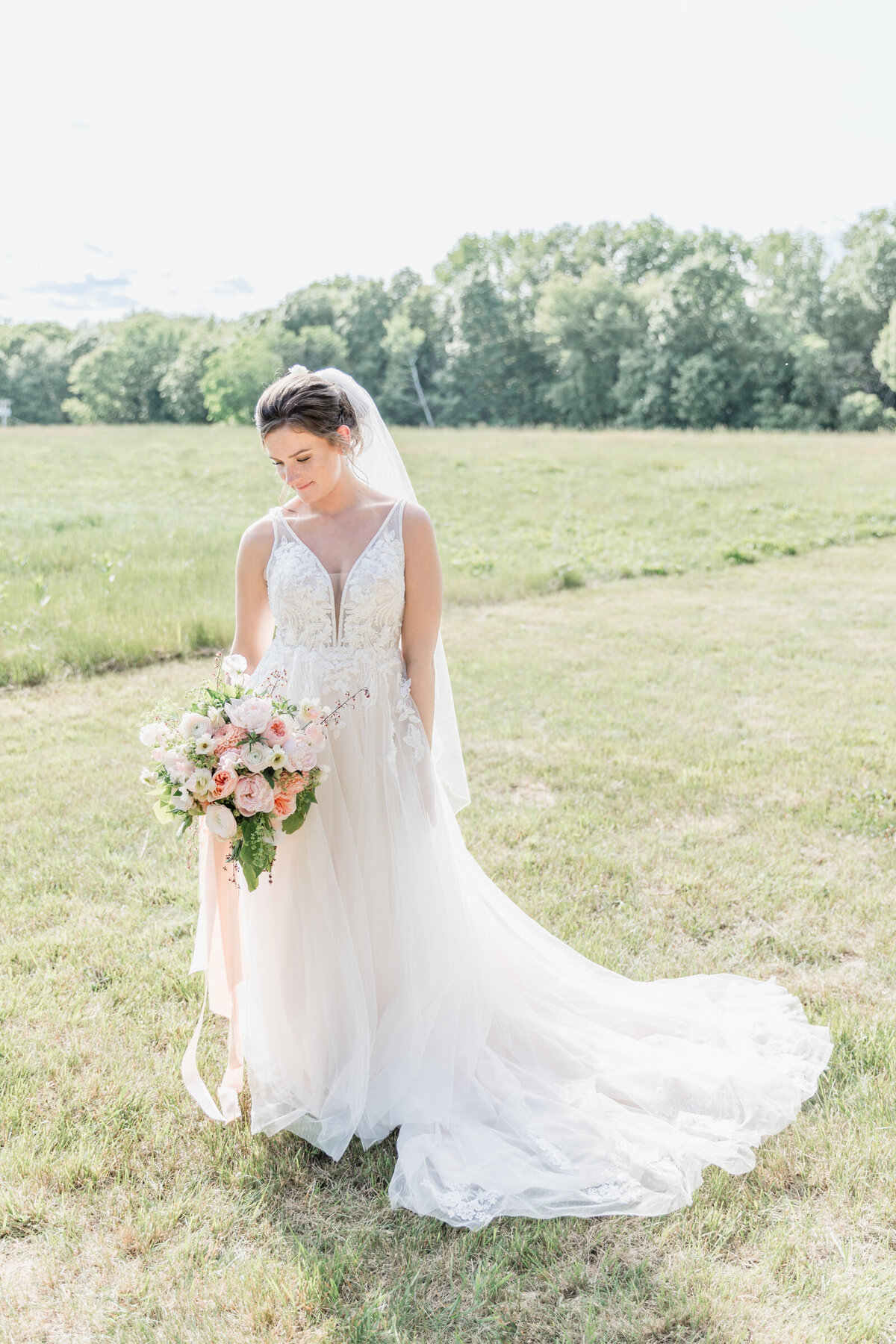 A bride looking down at her hand tied bouquet