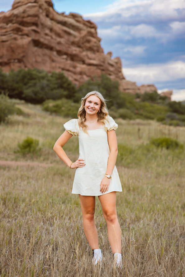 Girl puts hand on hip for senior photo at Red Rocks.