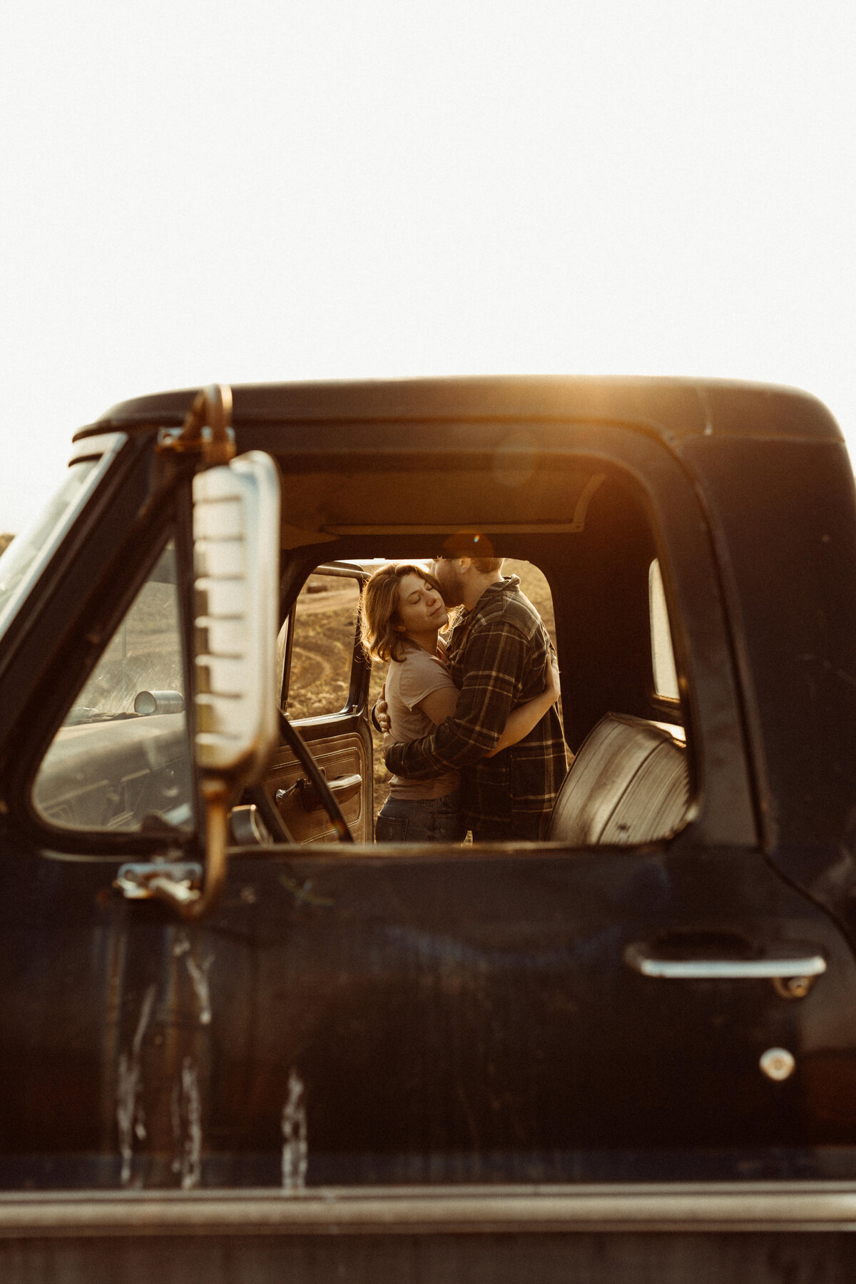 Antique truck frames couple kissing in Upstate NY