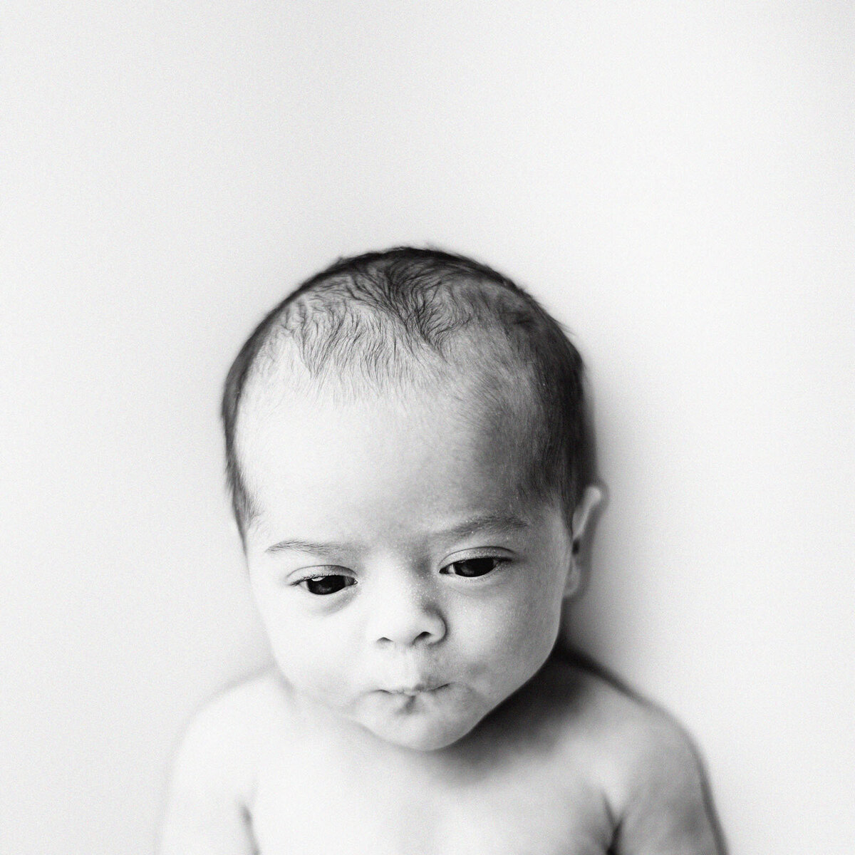 black and white image of newborn making a silly face