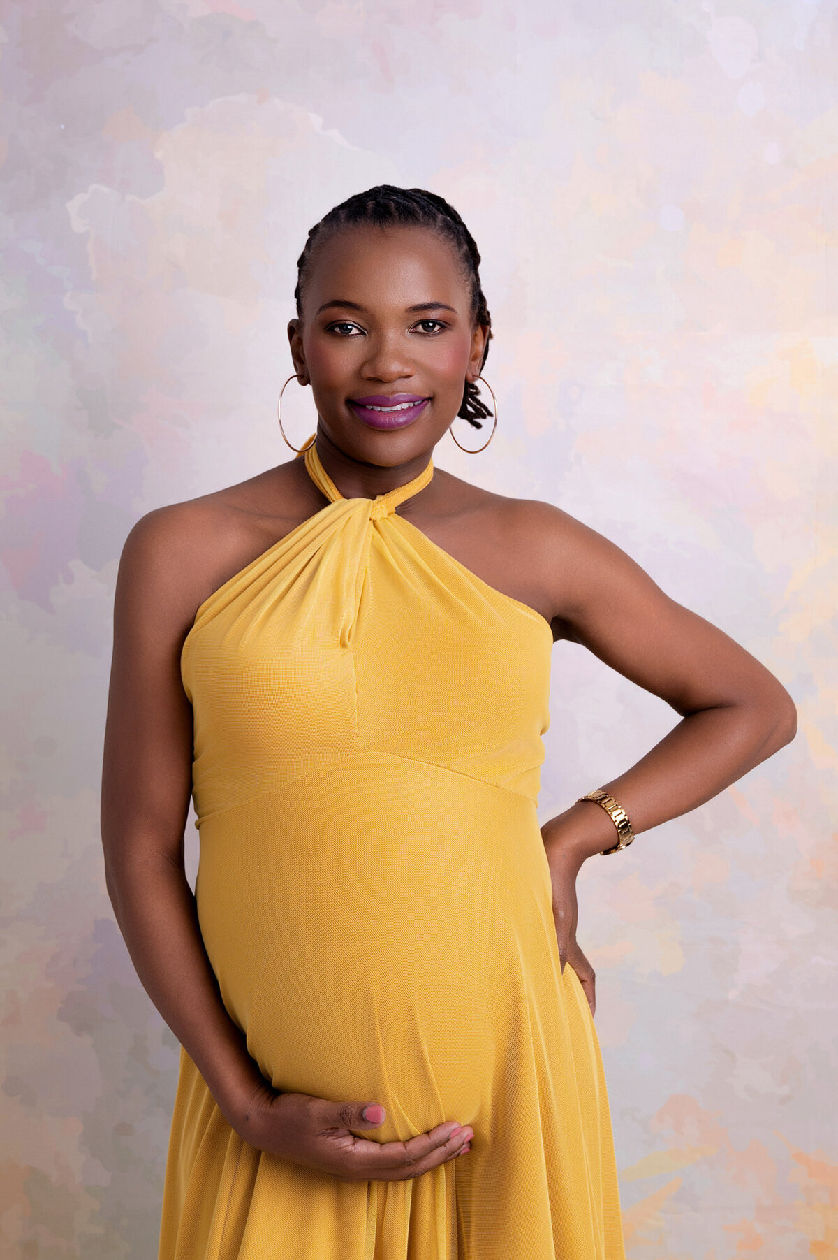Mom-to-be posing in elegant mustard yellow maternity gown.