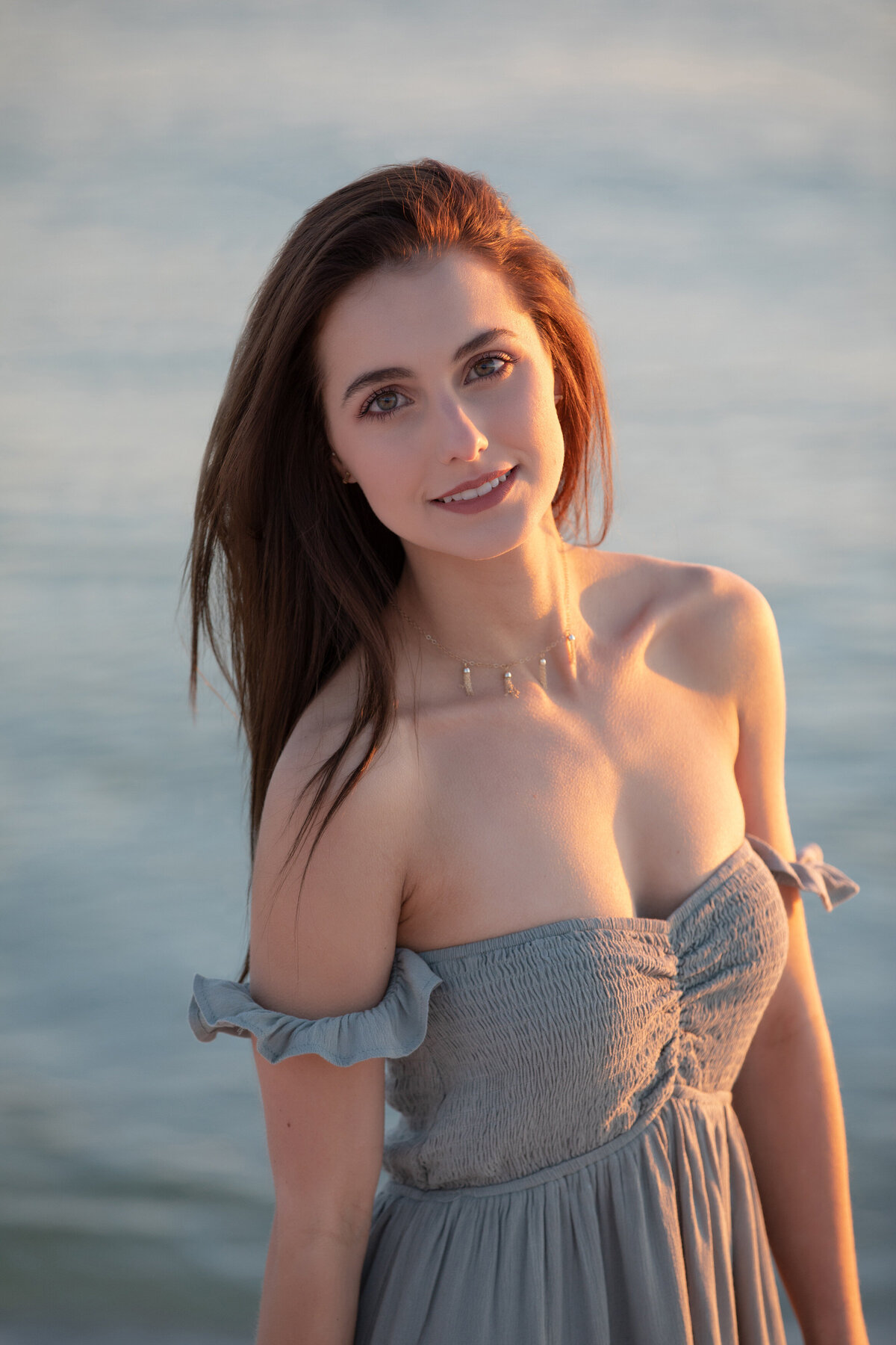 A young girl in a strapless dress smiling