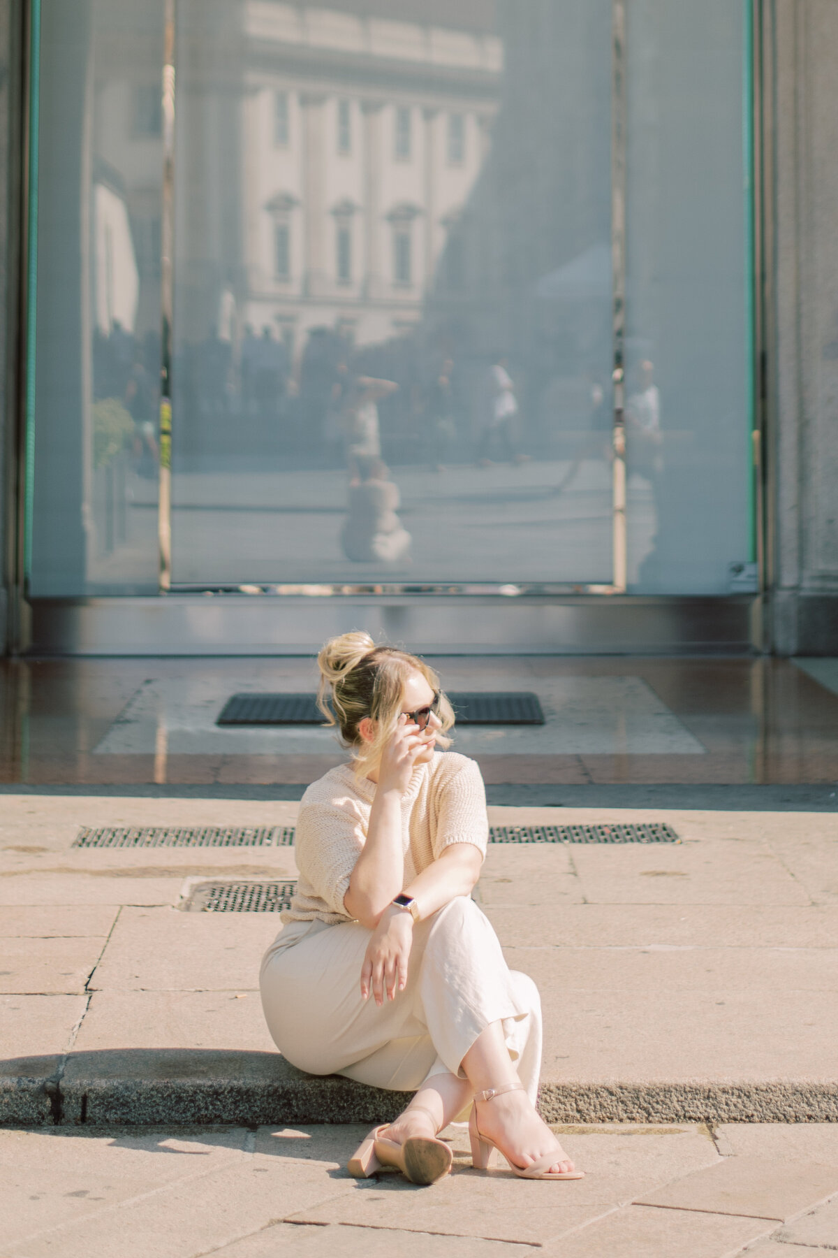 Mother gently holding child on steps of a Milanese storefront, embodying serene family connection