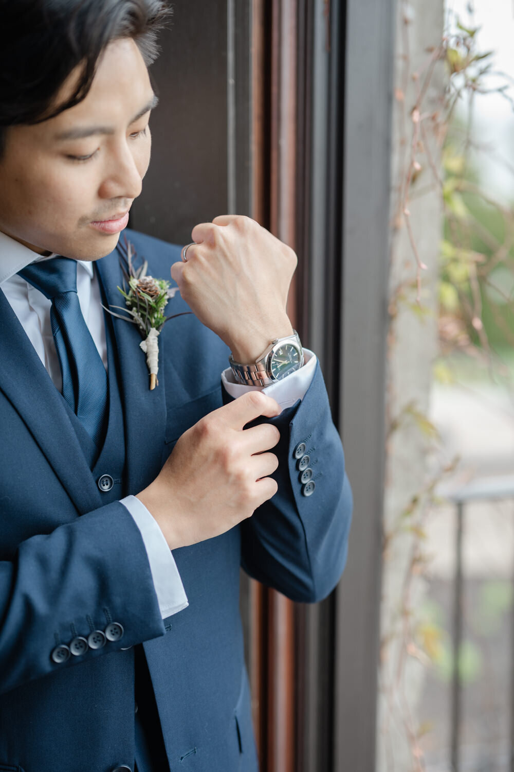 The groom-to-be adjusts his cufflinks to complete his look — an elegant and polished gesture during a distinguished wedding celebration in Montreal