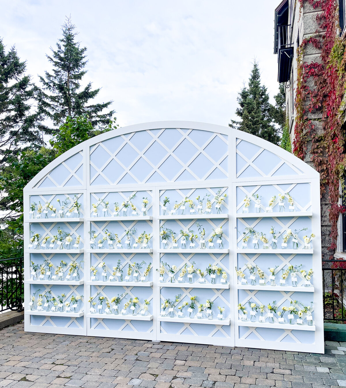 A place card display at a Montreal wedding is decorated with individual vases of flowers. 