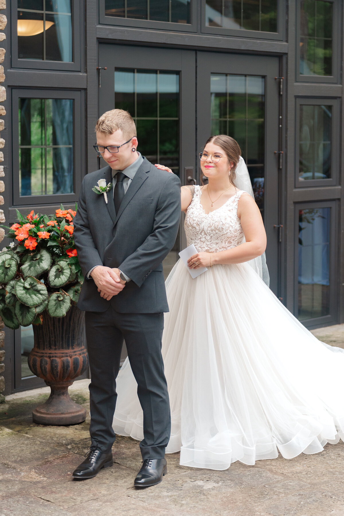 bride tapping groom on the shoulder for their first look