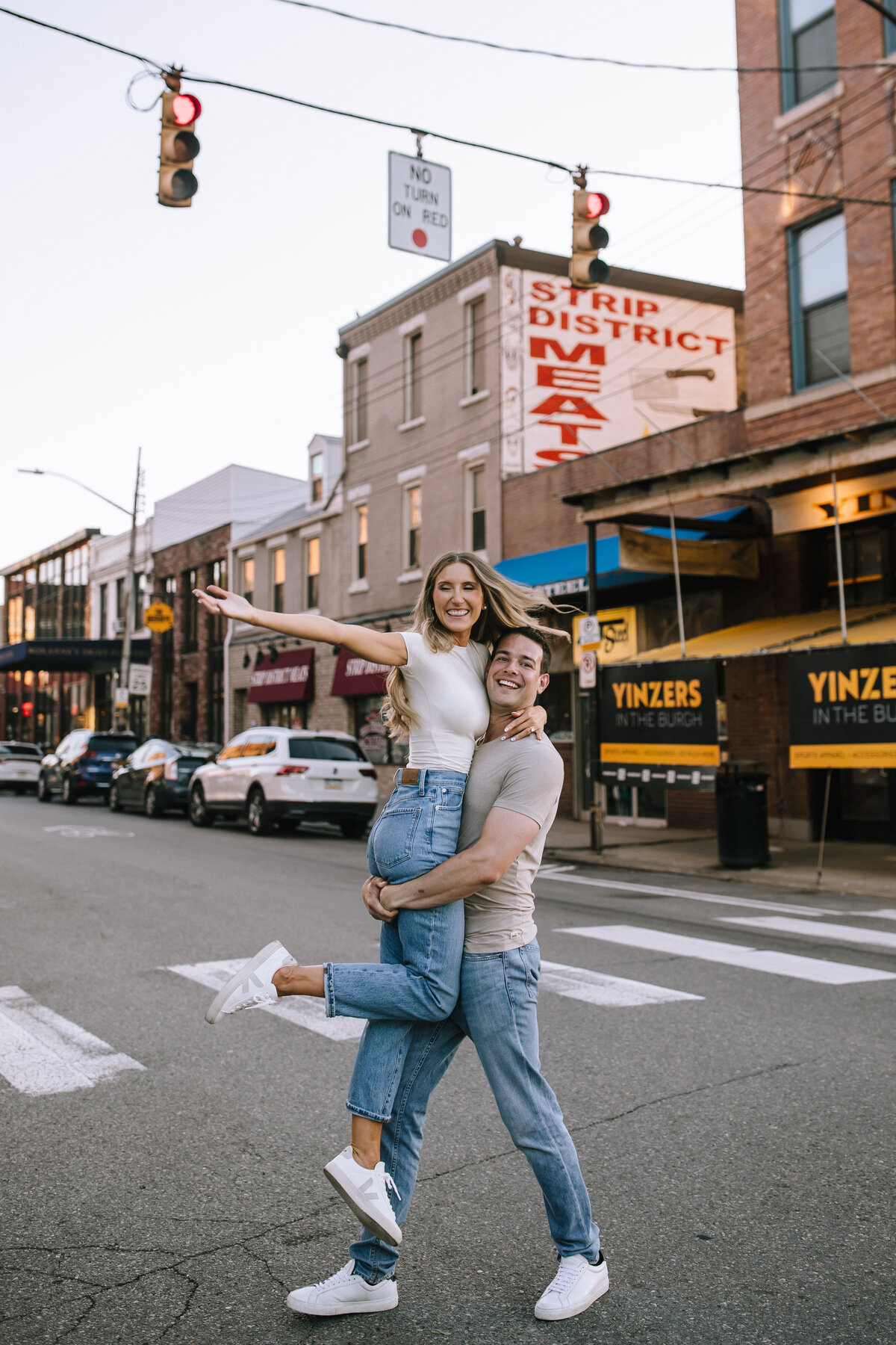 Engaged couple dancing in the streets of the Pittsburgh strip district.